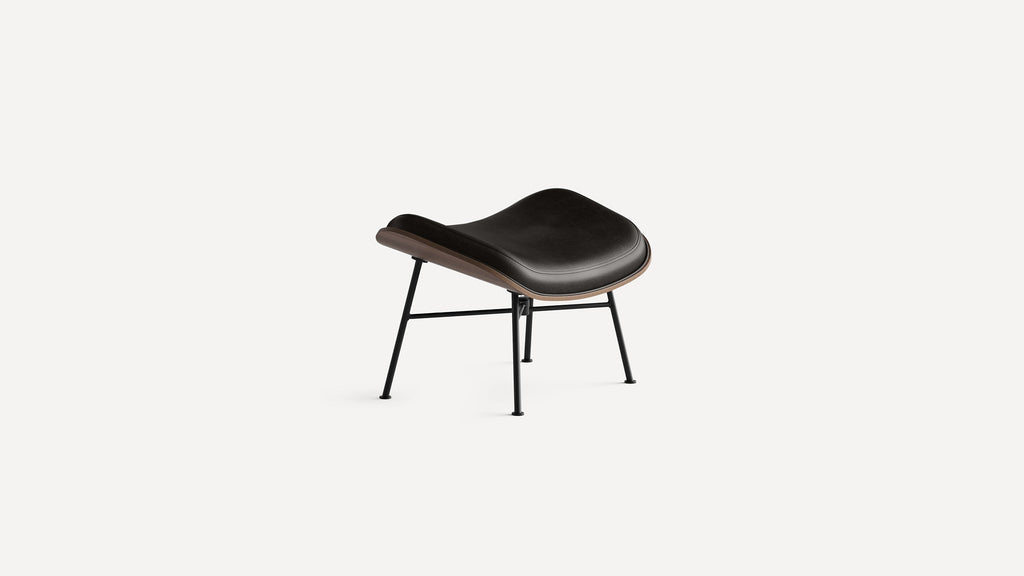 Modern black leather ottoman with curved wooden frame and slender black metal legs on a white background.