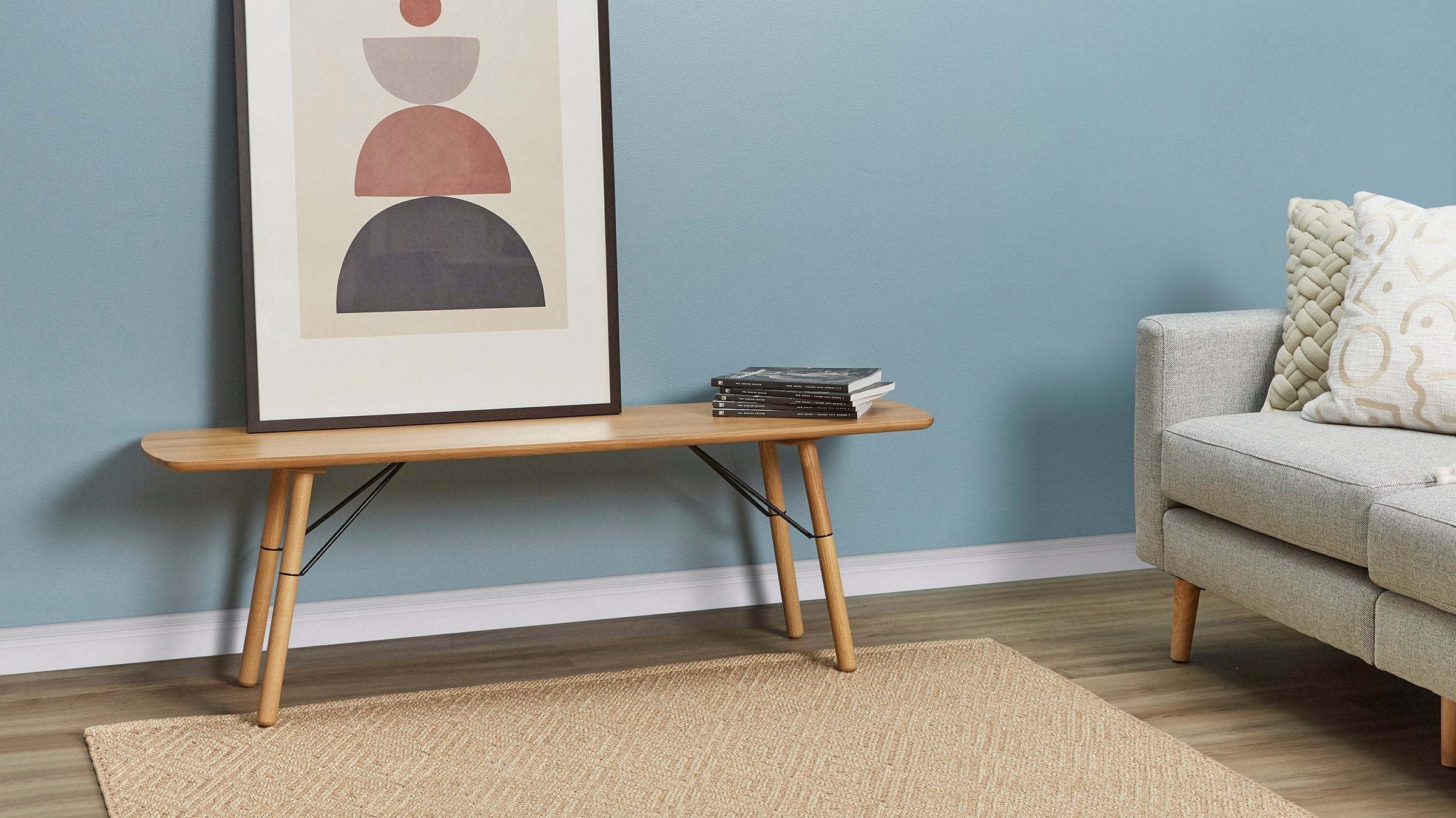 a modern living room with a gray sofa and a wooden coffee table
