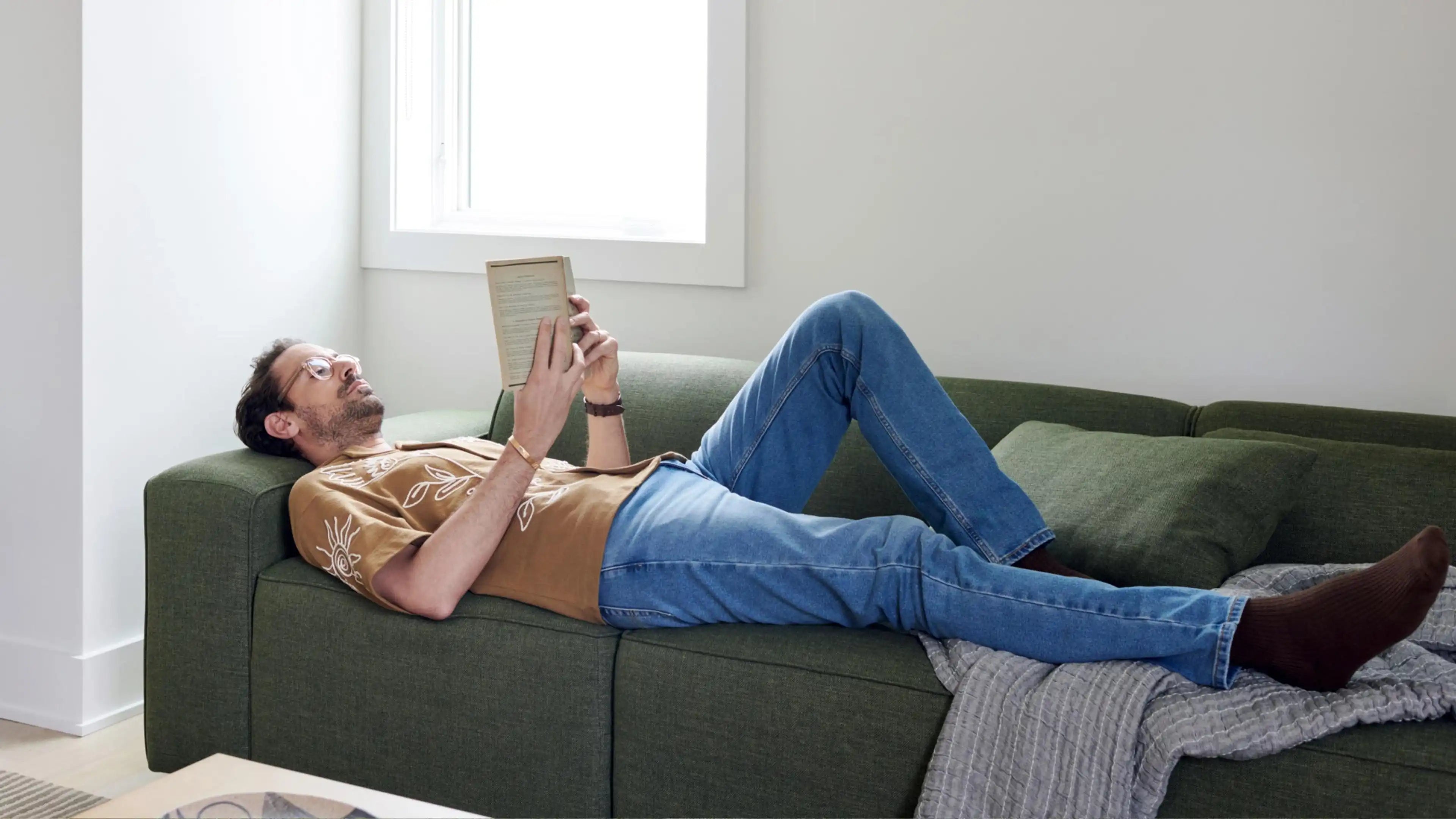 man laying on a green couch