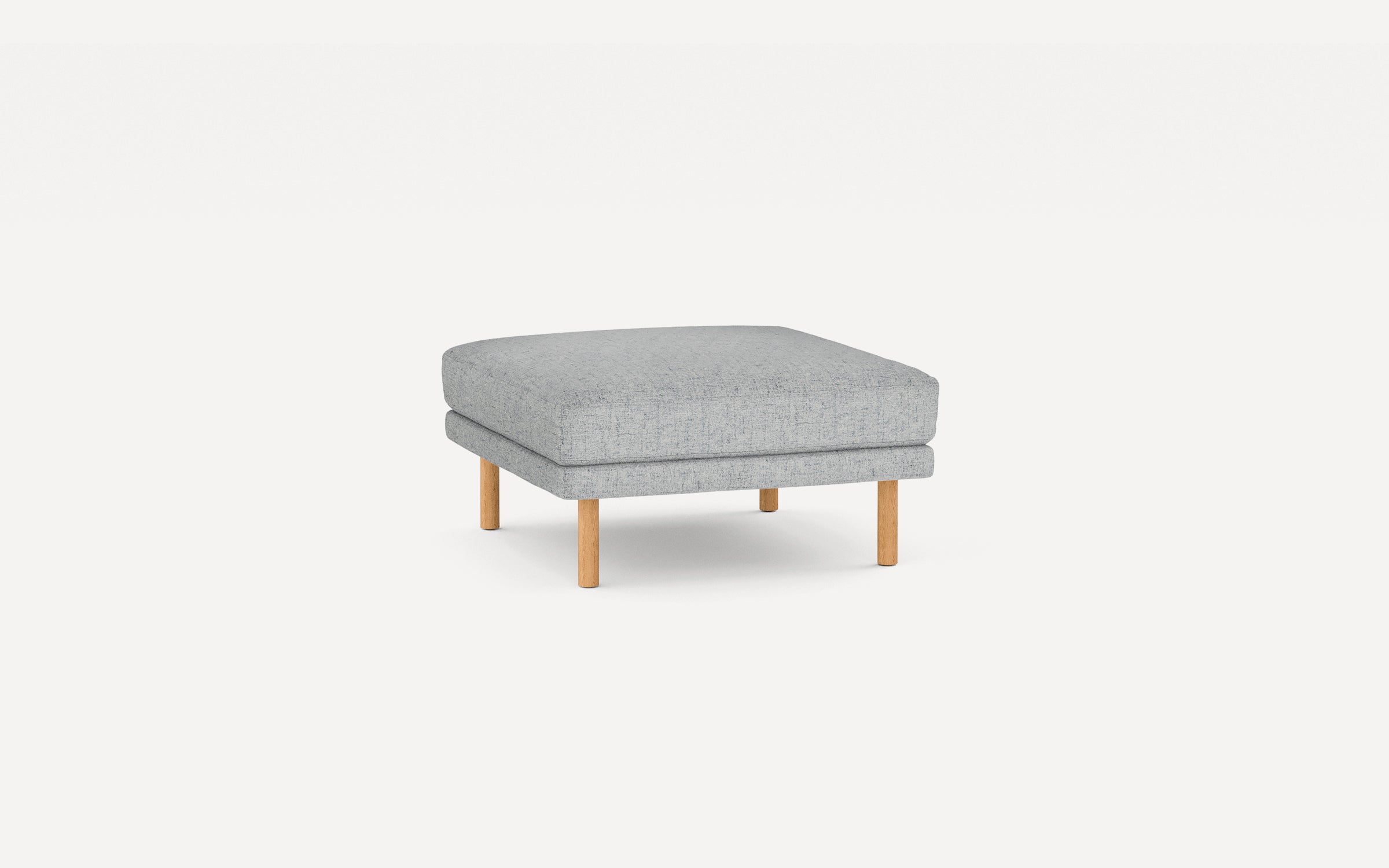 Square light gray upholstered ottoman with four short wooden legs on a white background.