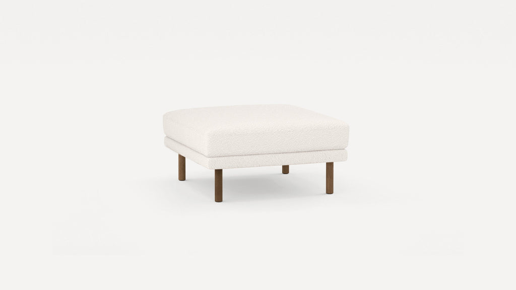 Square ottoman with white textured upholstery and four short wooden legs on a plain white background.