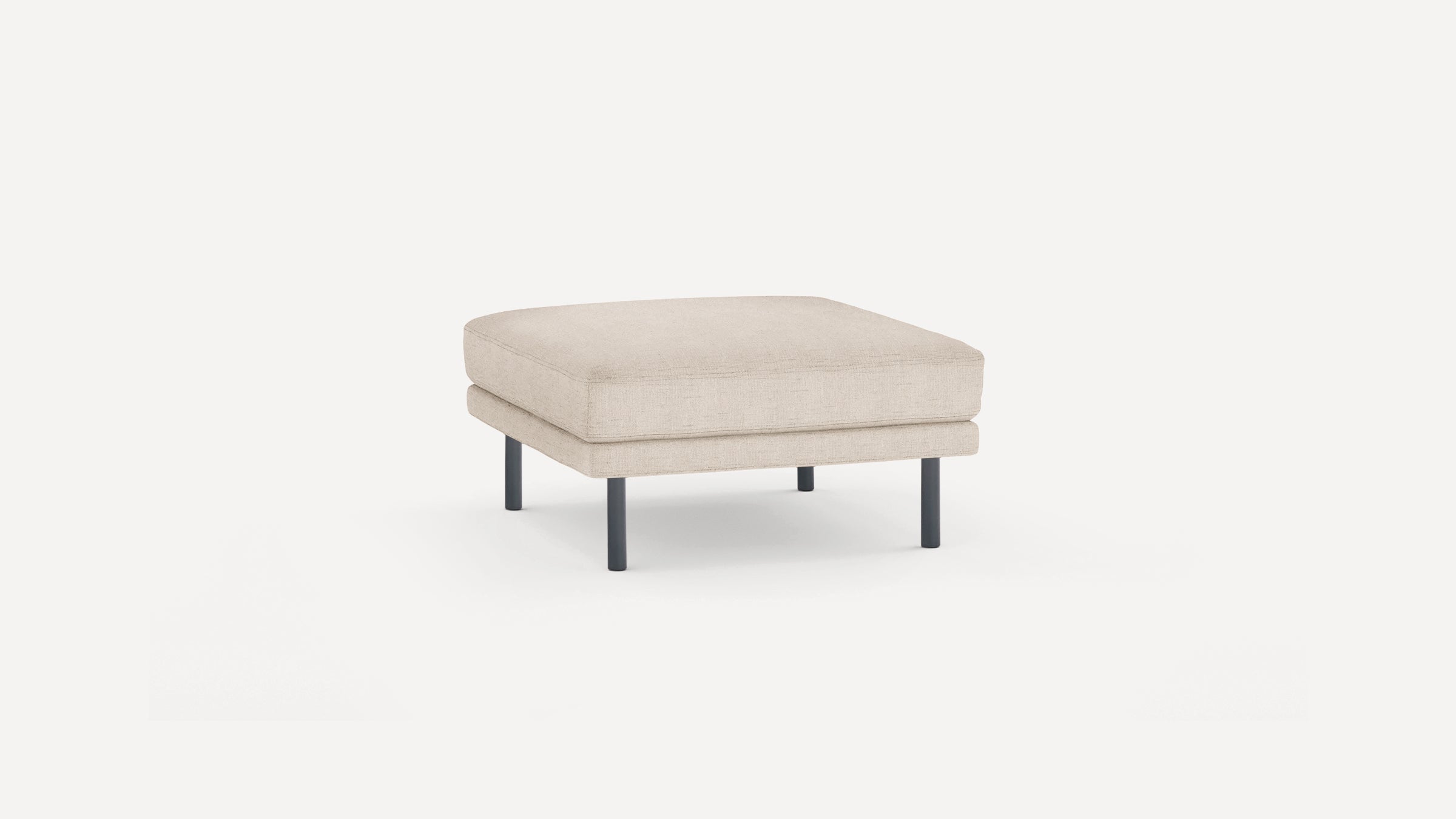 Square beige fabric ottoman with thick cushion and four short black metal legs on a white background.