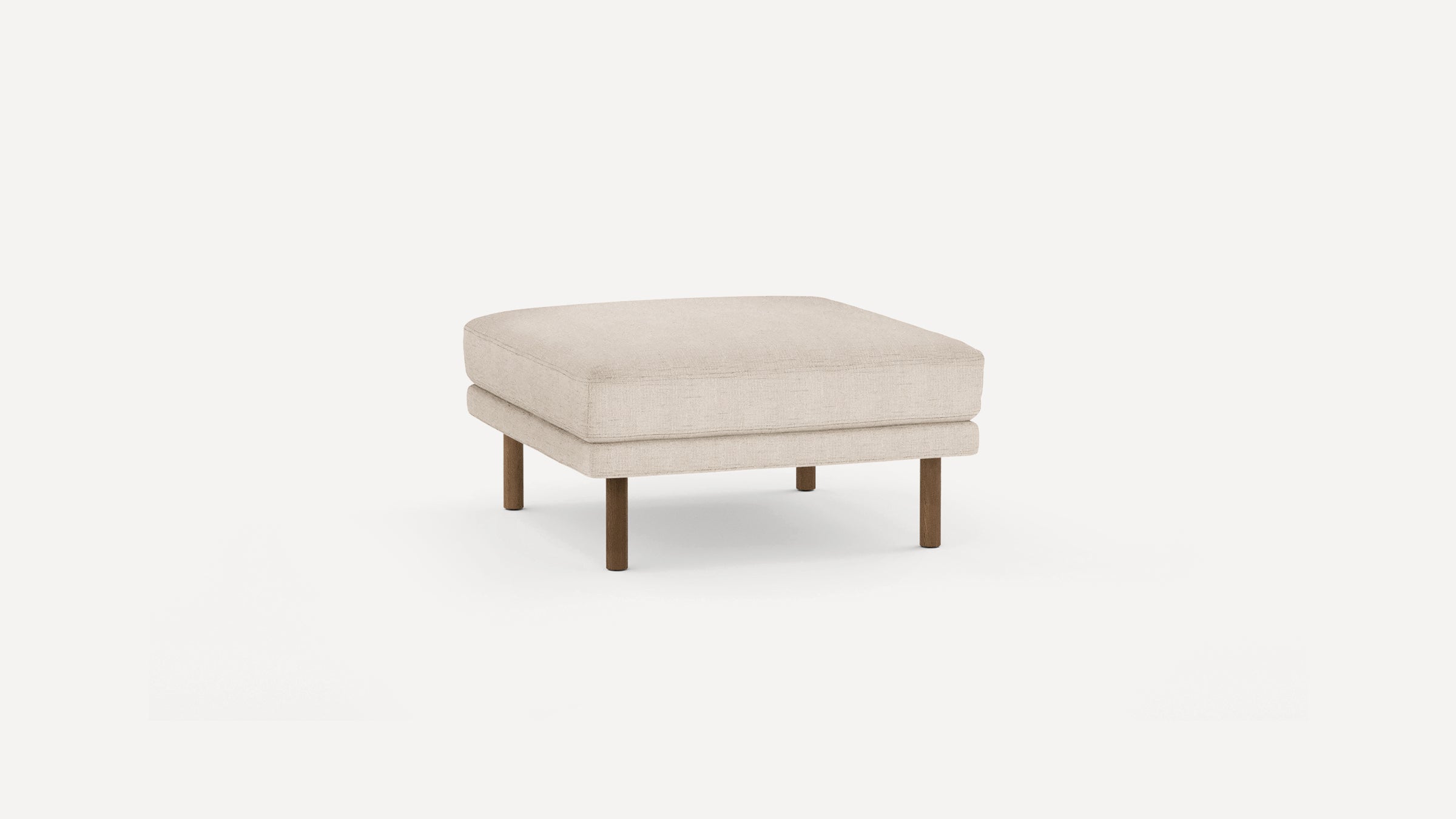 Square beige upholstered ottoman with thick cushioned top and four cylindrical wooden legs.