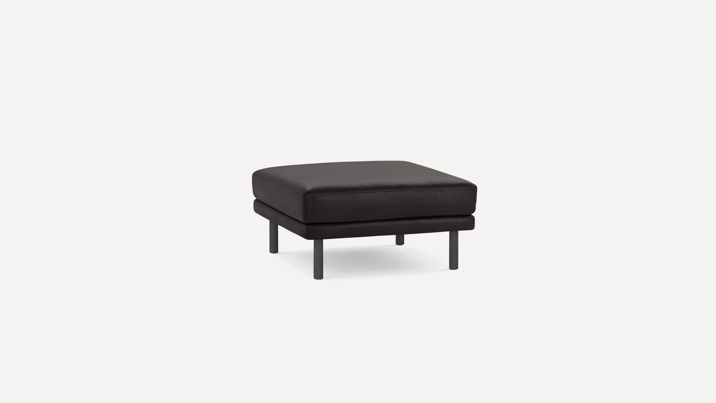 Square black leather ottoman with four short metal legs, minimalist modern design on a white background.