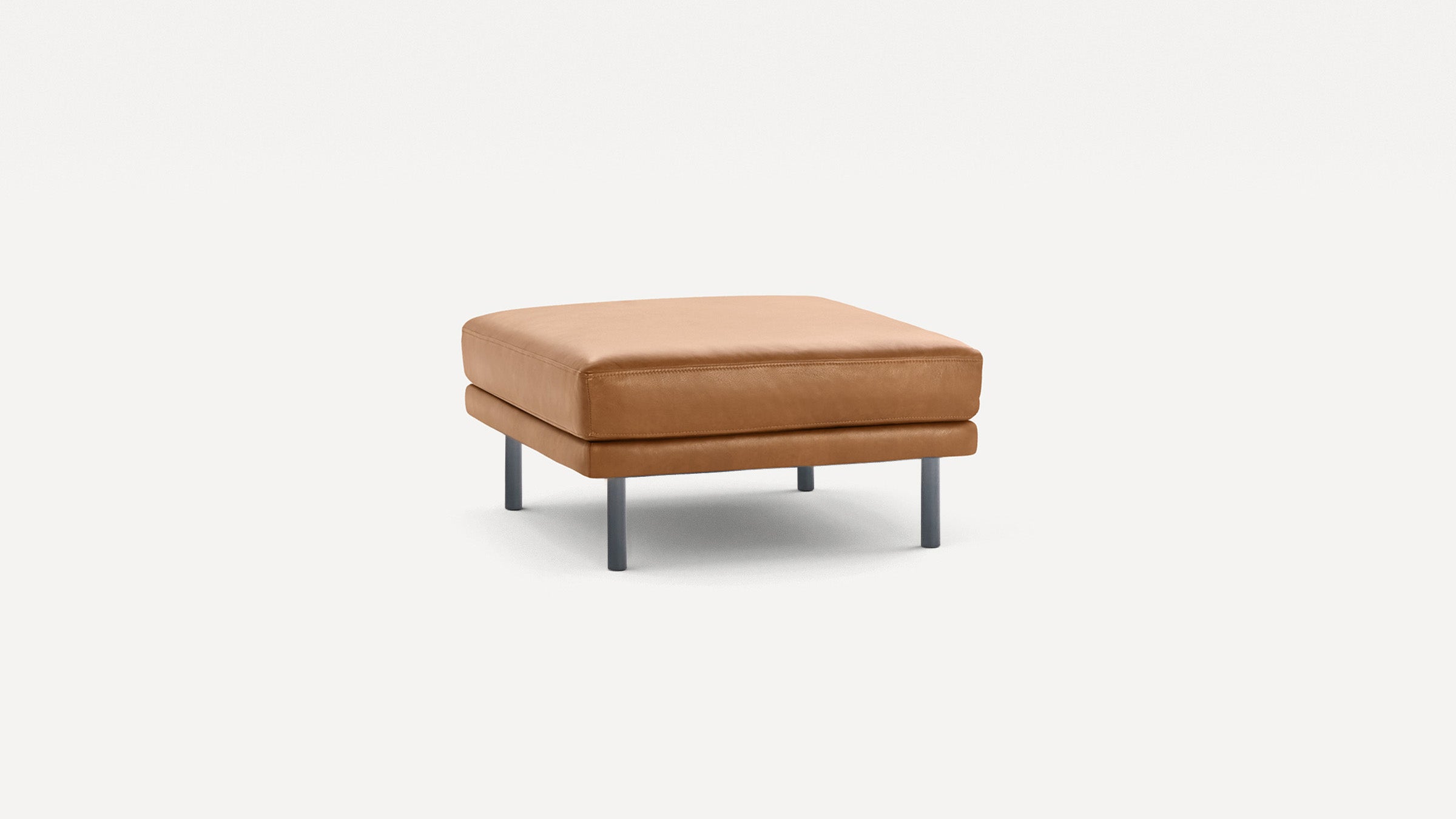 Square tan leather ottoman with metal legs, featuring a cushioned top and modern, minimalist design.
