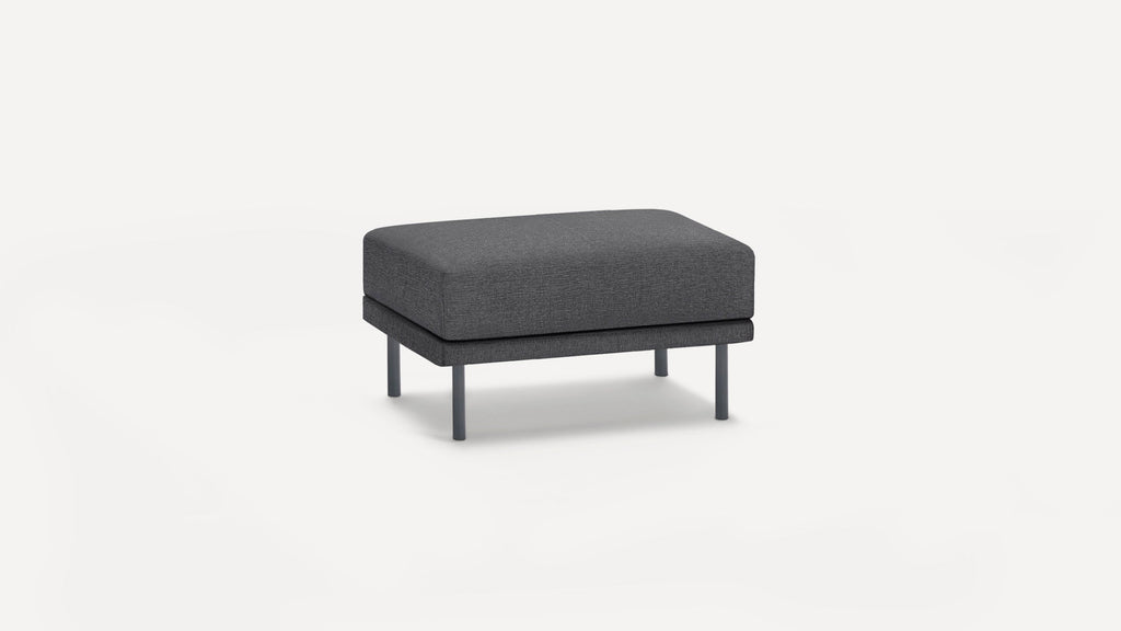 Dark gray modern rectangular ottoman with fabric upholstery and four metal legs on a white background.