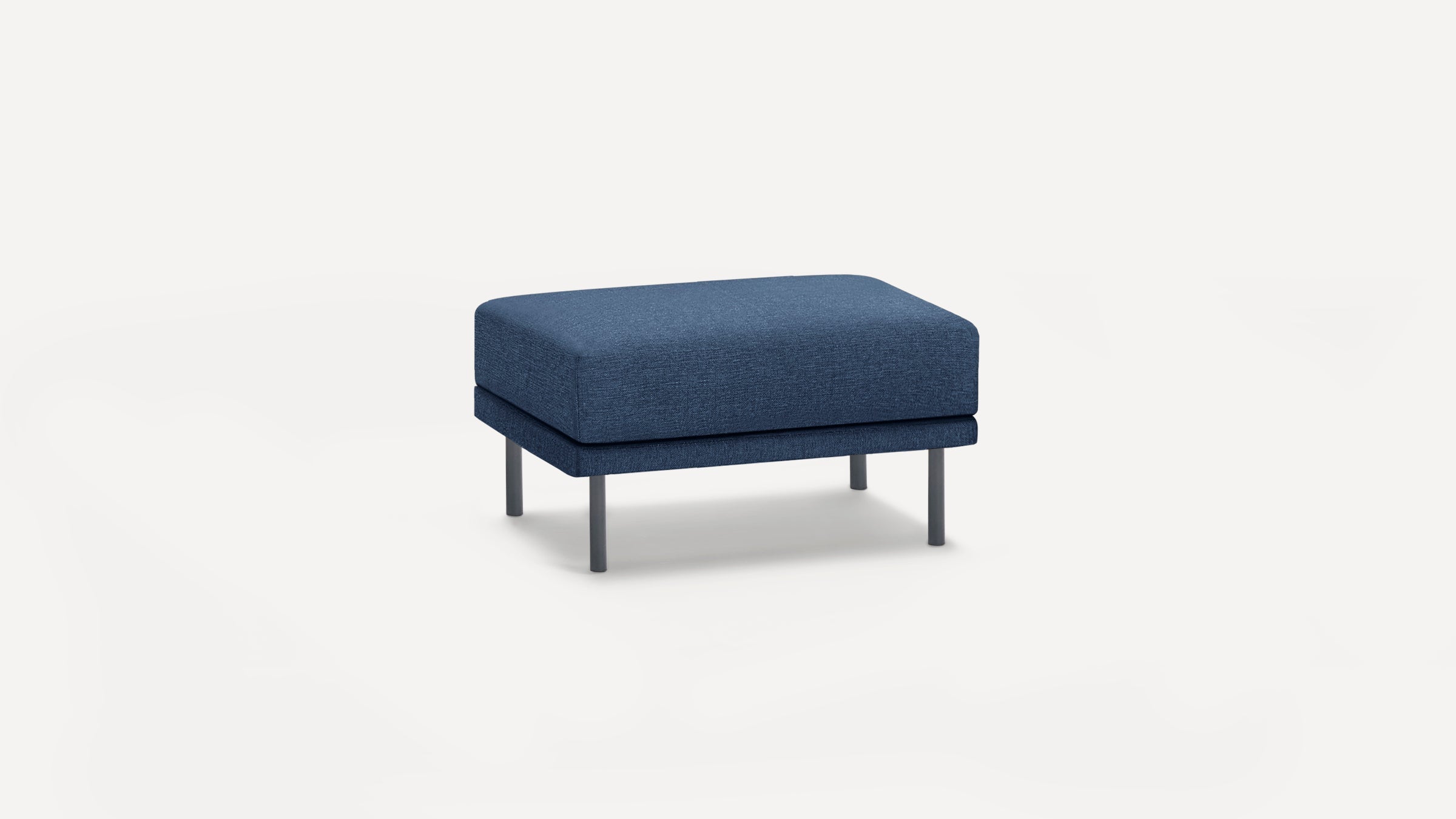 Rectangular dark blue upholstered ottoman with four slim metal legs, minimalist modern design, isolated on white background.