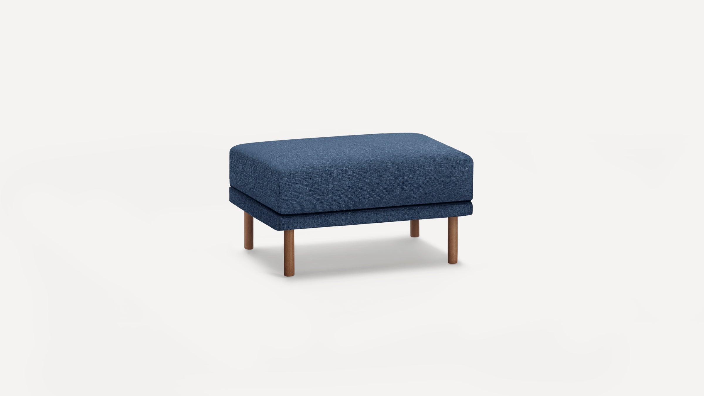 Rectangular ottoman with dark blue fabric upholstery and four wooden legs, displayed on a white background.