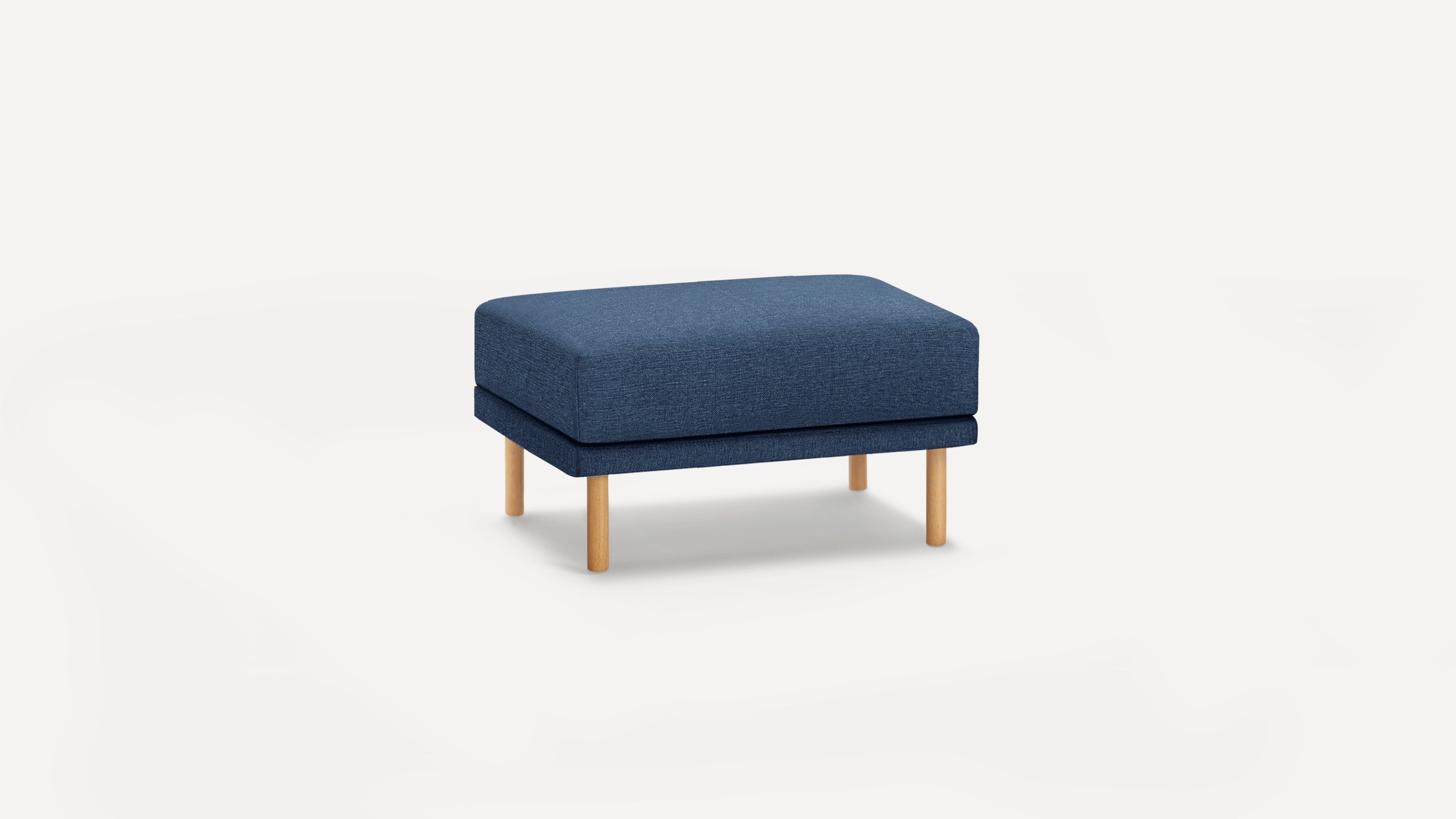 Rectangular blue upholstered ottoman with four light wooden legs, showcasing a minimalist modern design on a white background.
