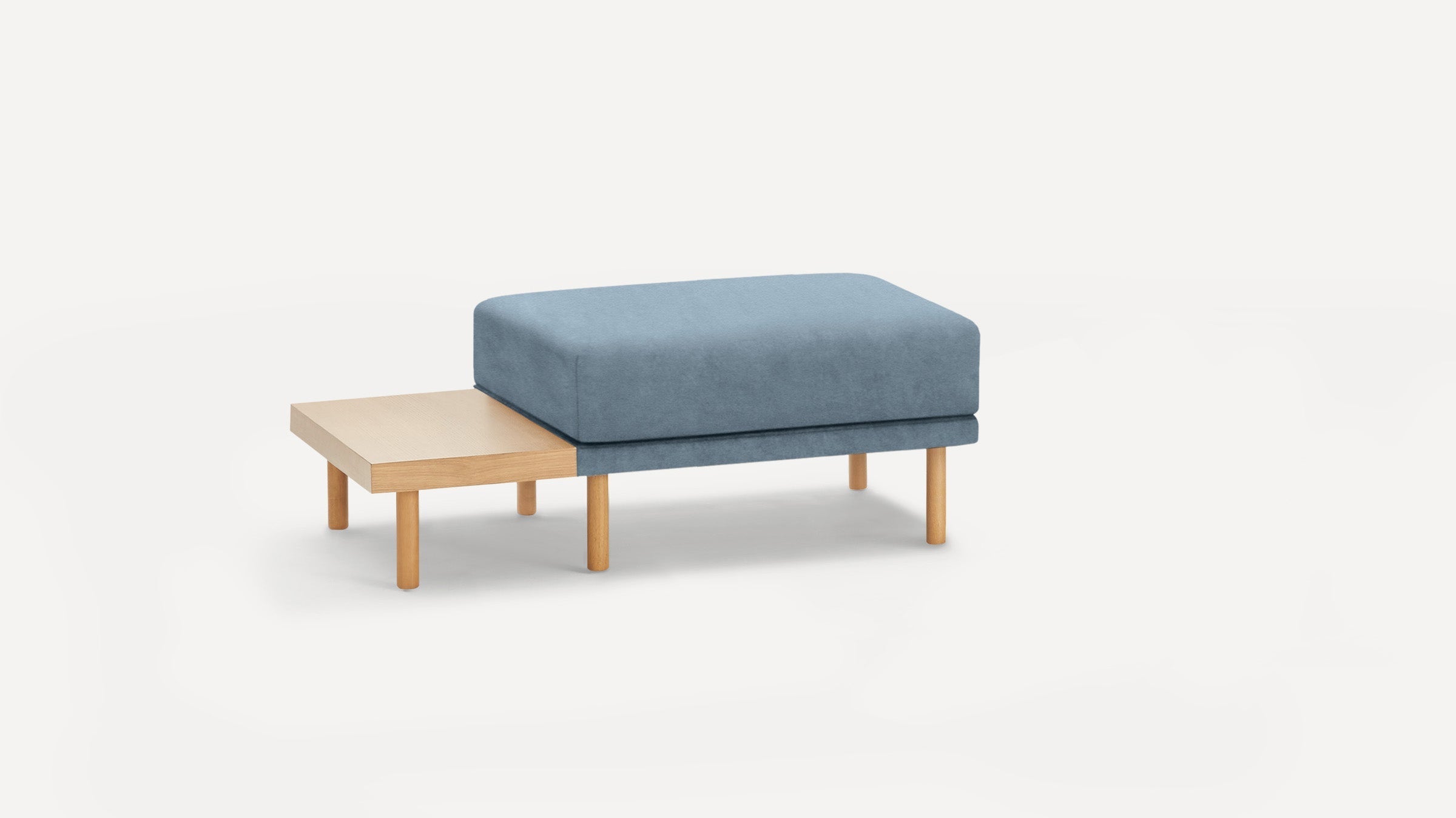 Modern rectangular ottoman with soft blue cushion and attached wooden side table on cylindrical wooden legs.