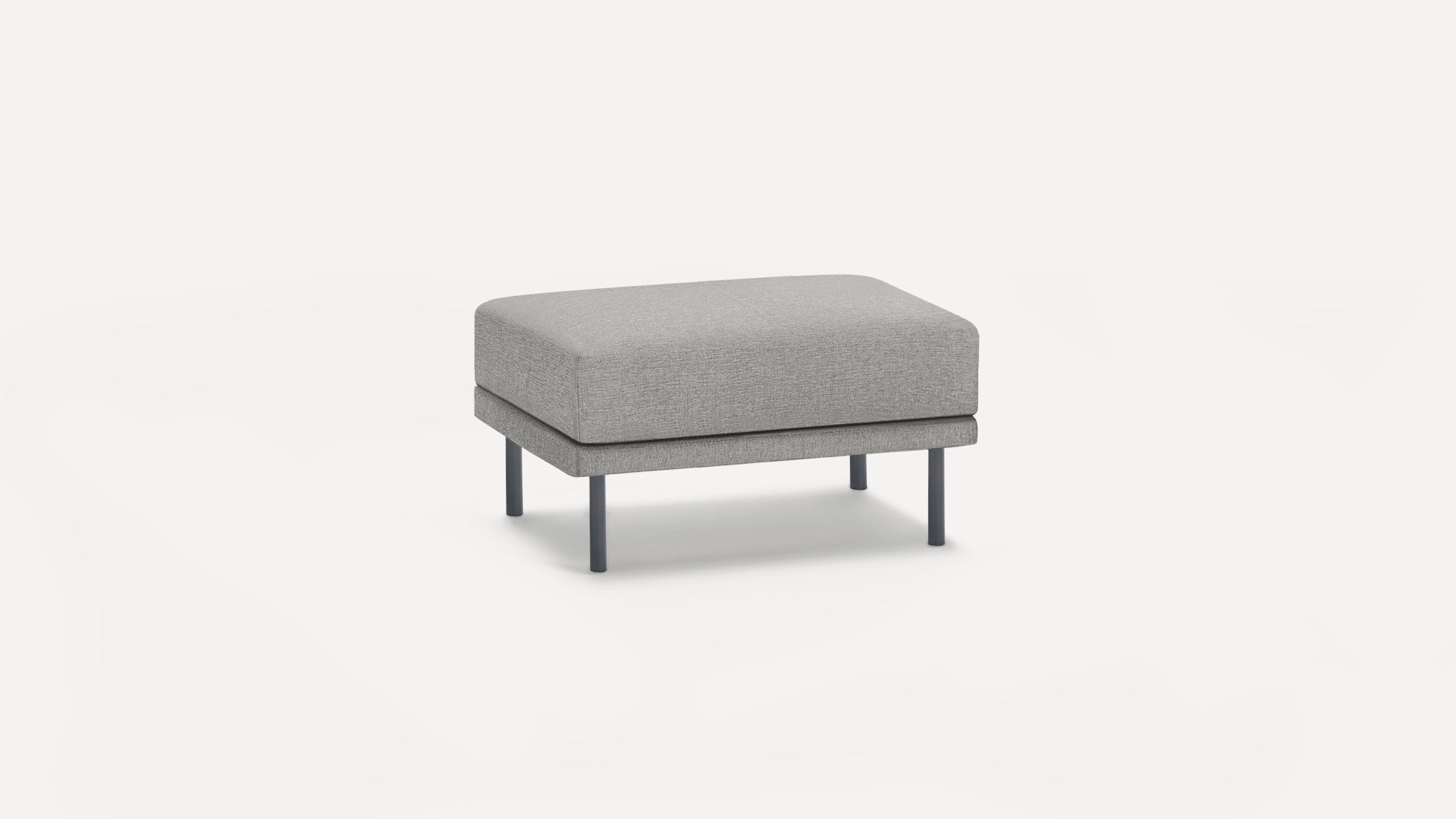Modern rectangular gray ottoman with fabric upholstery, supported by four slim black metal legs.