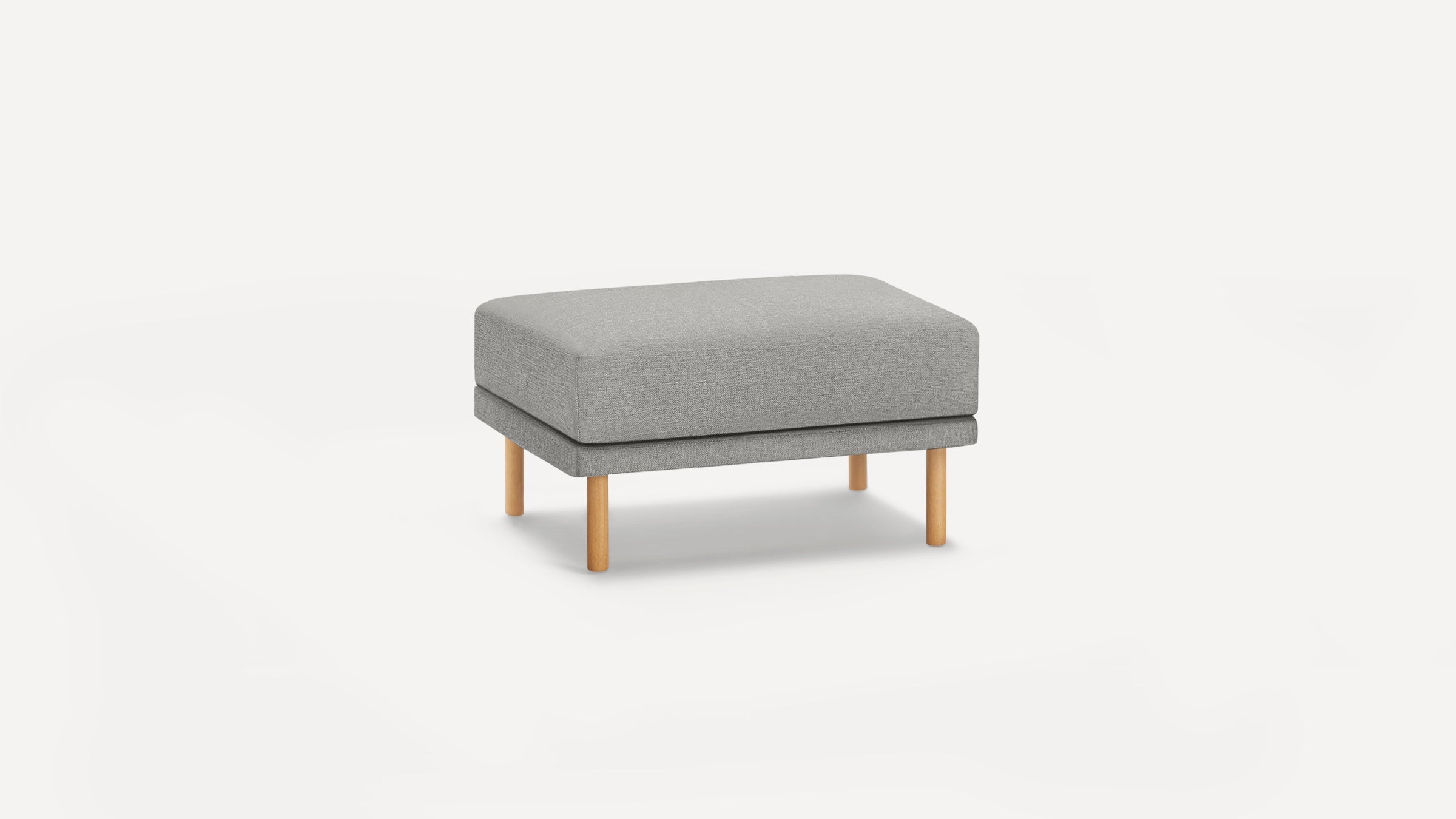 Rectangular gray upholstered ottoman with four round wooden legs, minimalist modern design on white background.