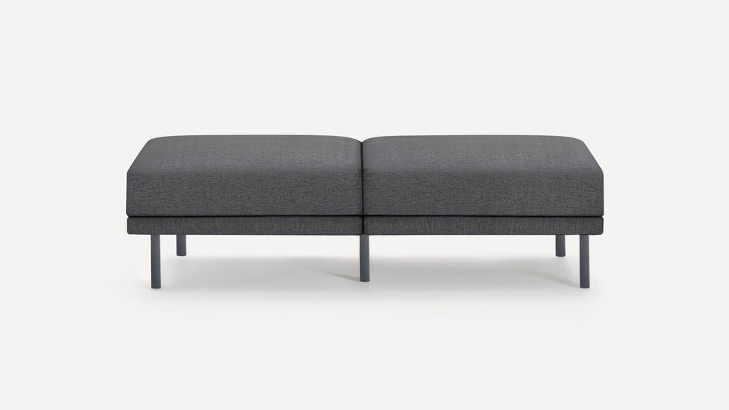 Modern dark gray fabric bench with rectangular cushion and five sturdy cylindrical legs, minimalist design on white background.
