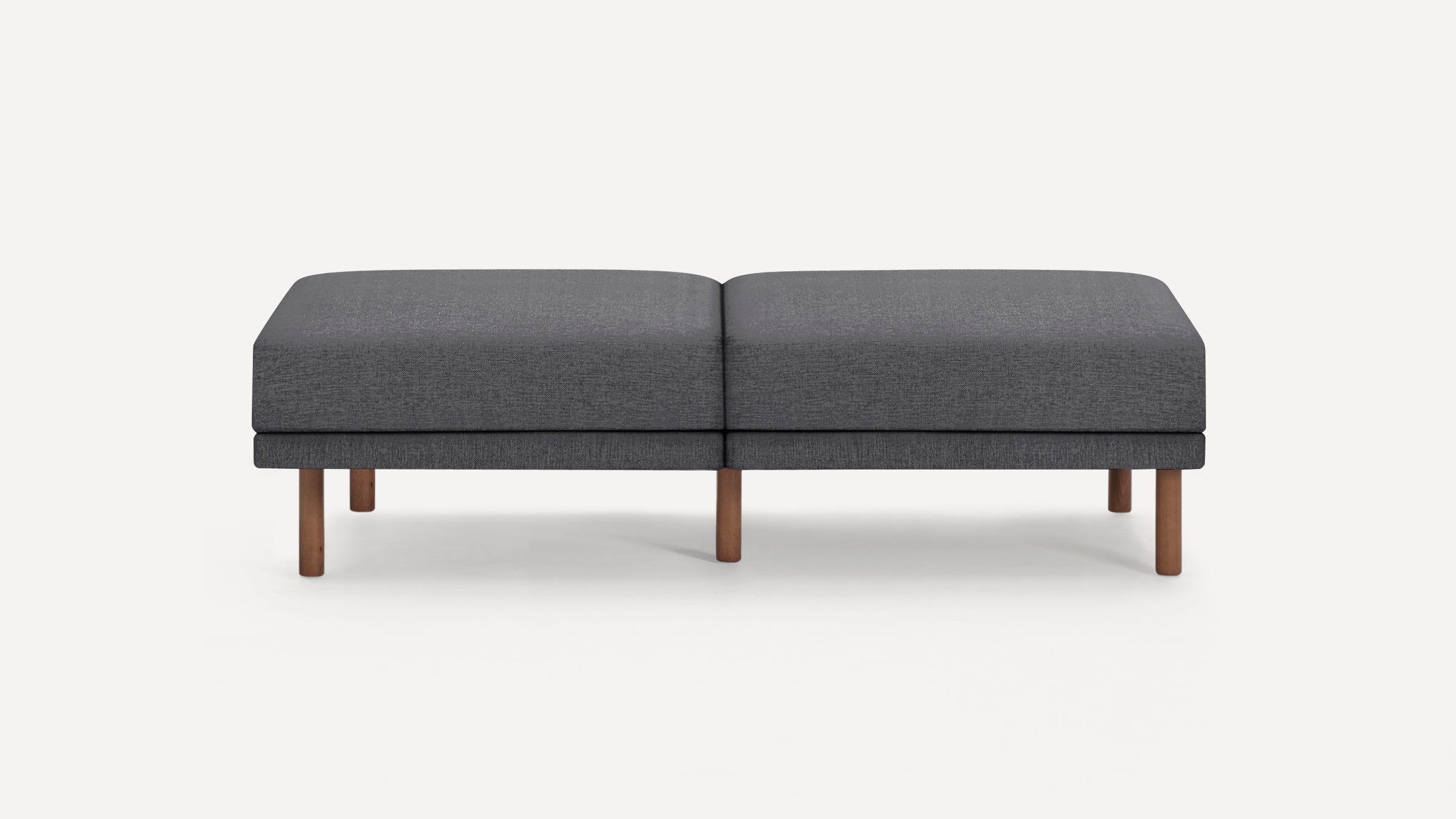 Modern dark gray rectangular ottoman with smooth fabric upholstery and six short wooden legs, displayed against a plain white background.
