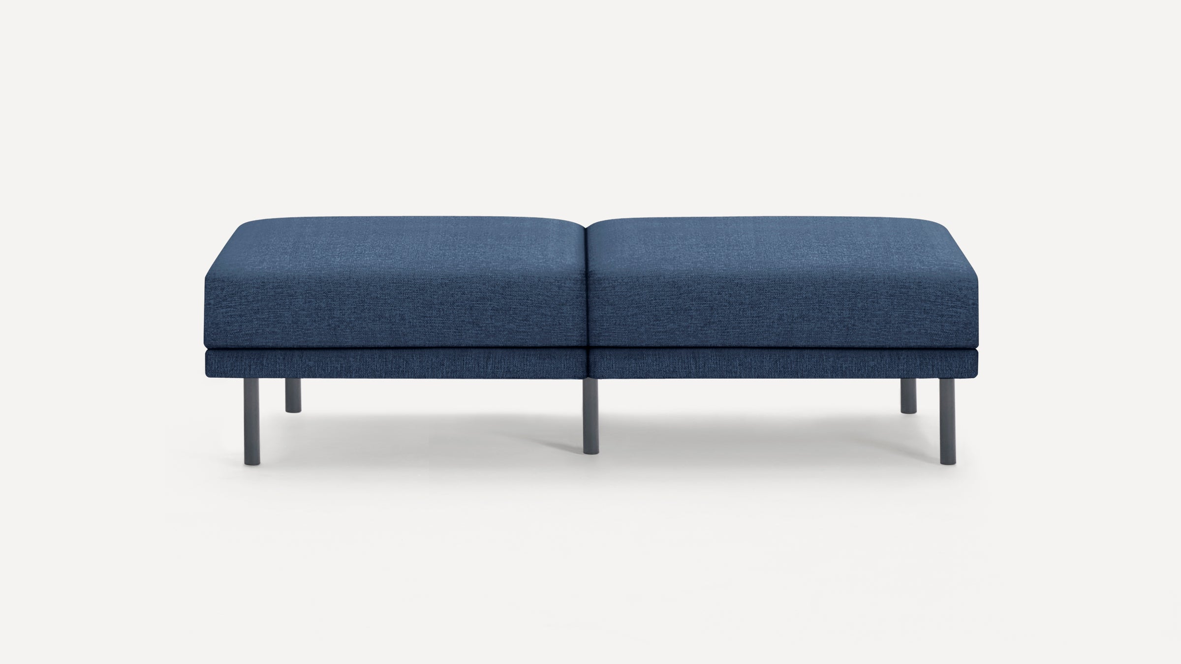 Modern rectangular blue upholstered bench with four slim metal legs on a white background.