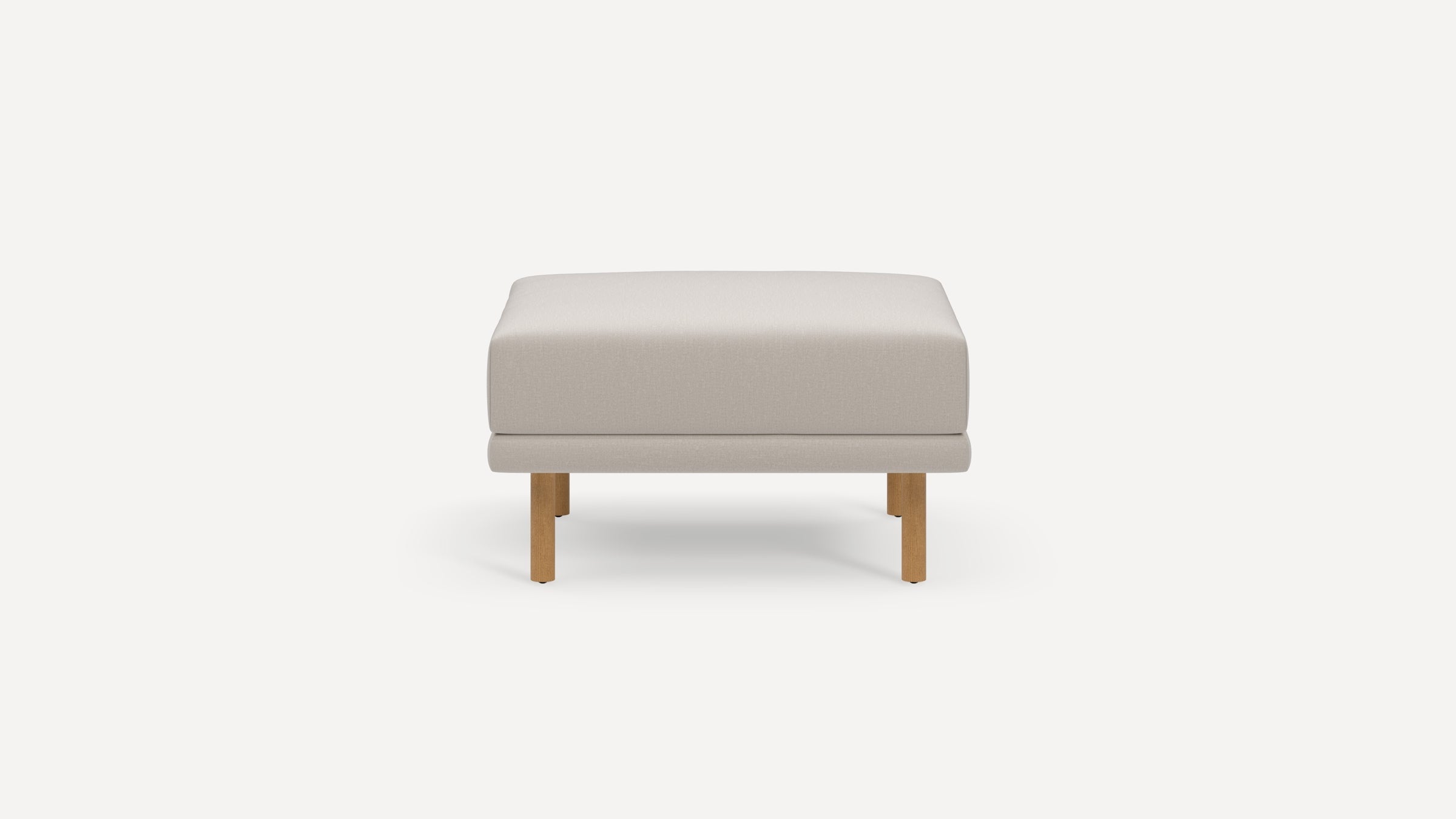 Minimalist square ottoman with light beige upholstered cushion and four wooden legs on a plain white background.