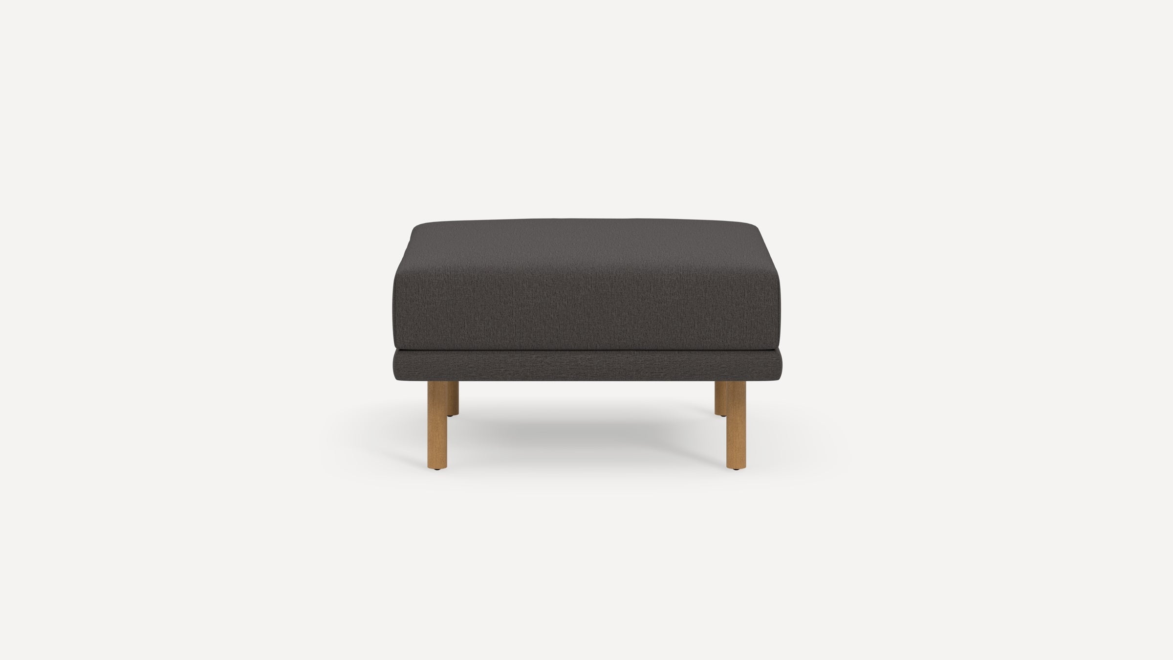 Square dark gray upholstered ottoman with four light wooden legs on a plain white background.