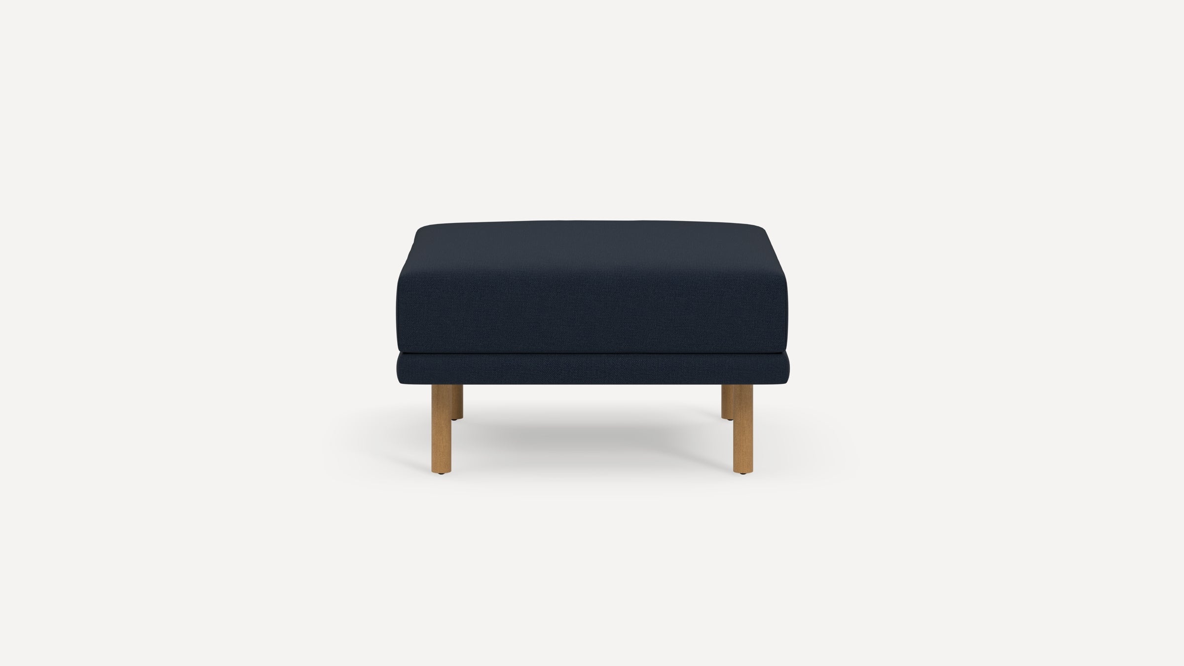Navy blue rectangular ottoman with wooden legs on a white background, featuring a cushioned top and simple, modern design.