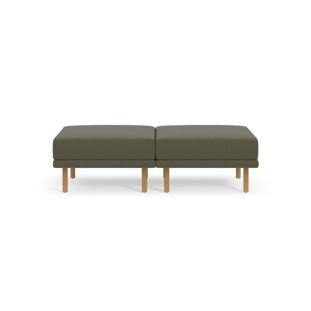 Two gray ottoman cushions with wooden legs, placed side by side on a black background.