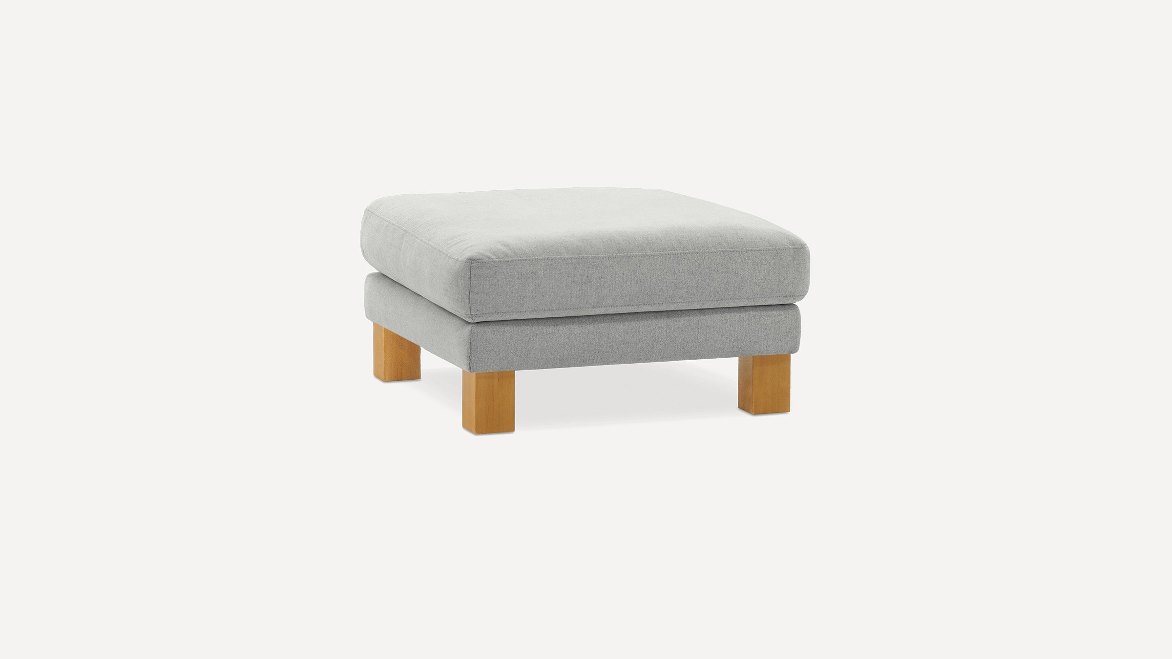 Square light gray cushioned ottoman with wooden square legs on a plain white background.