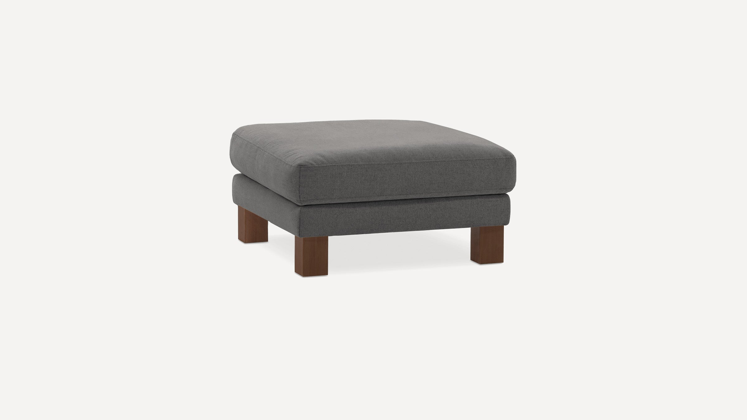 Square gray cushioned ottoman with wooden legs on a plain white background, minimal modern design.
