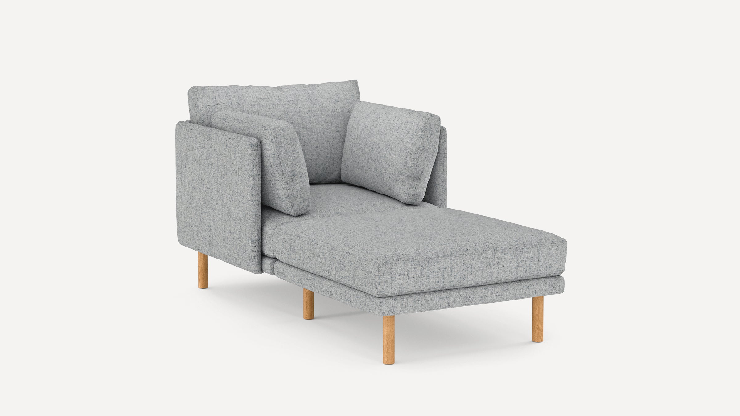 Light gray upholstered chaise lounge with wooden legs and three matching pillows against a white background.