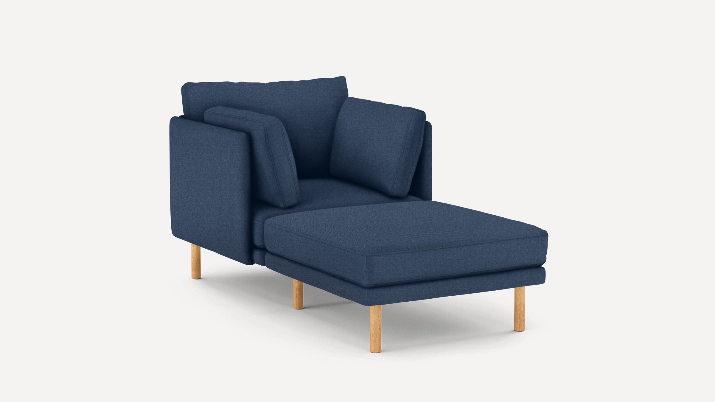 Modern navy blue chaise lounge with wooden legs and multiple cushioned pillows against a plain white background.