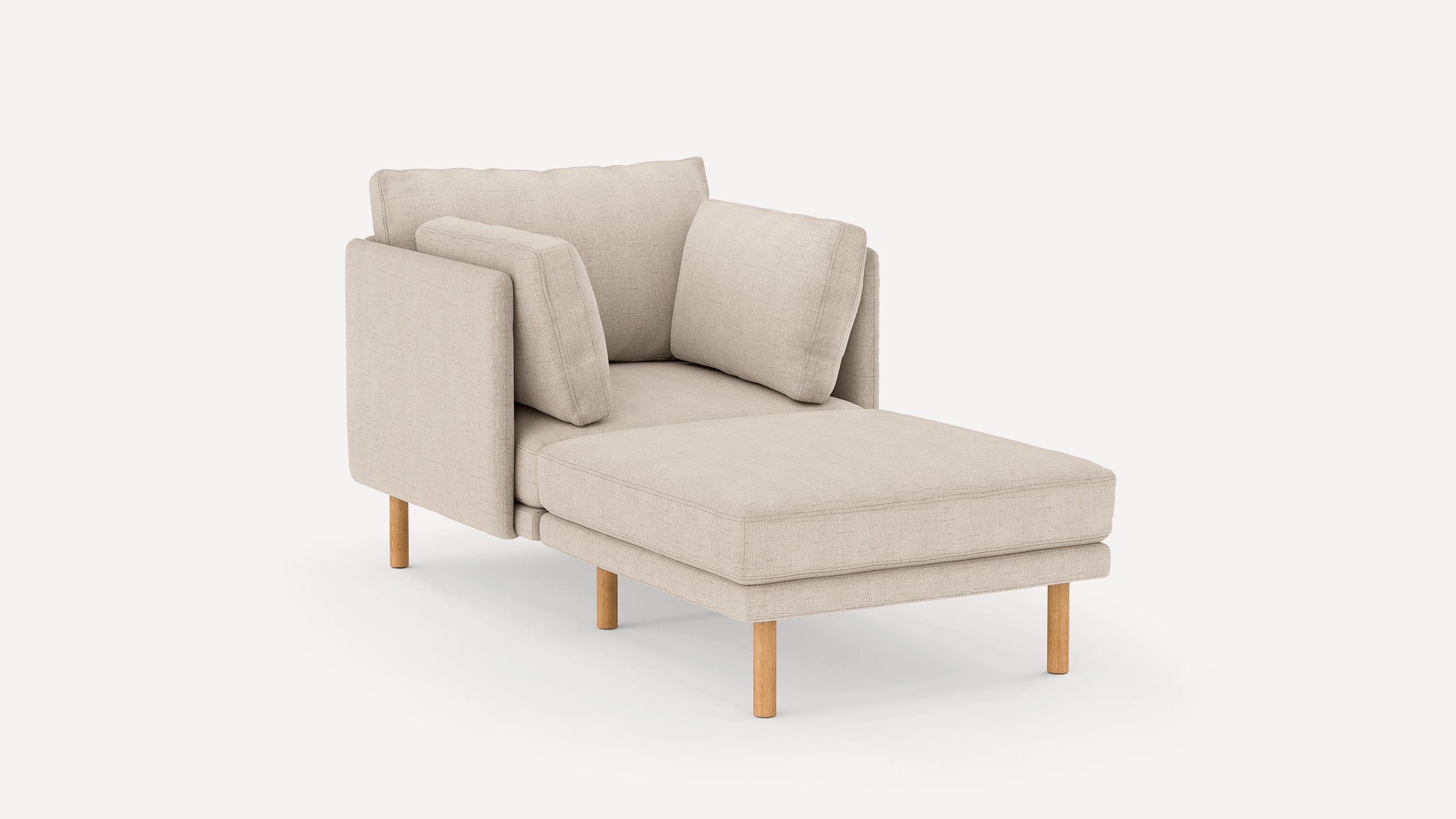 Beige upholstered chaise lounge with wooden legs and three matching cushions against a white background.