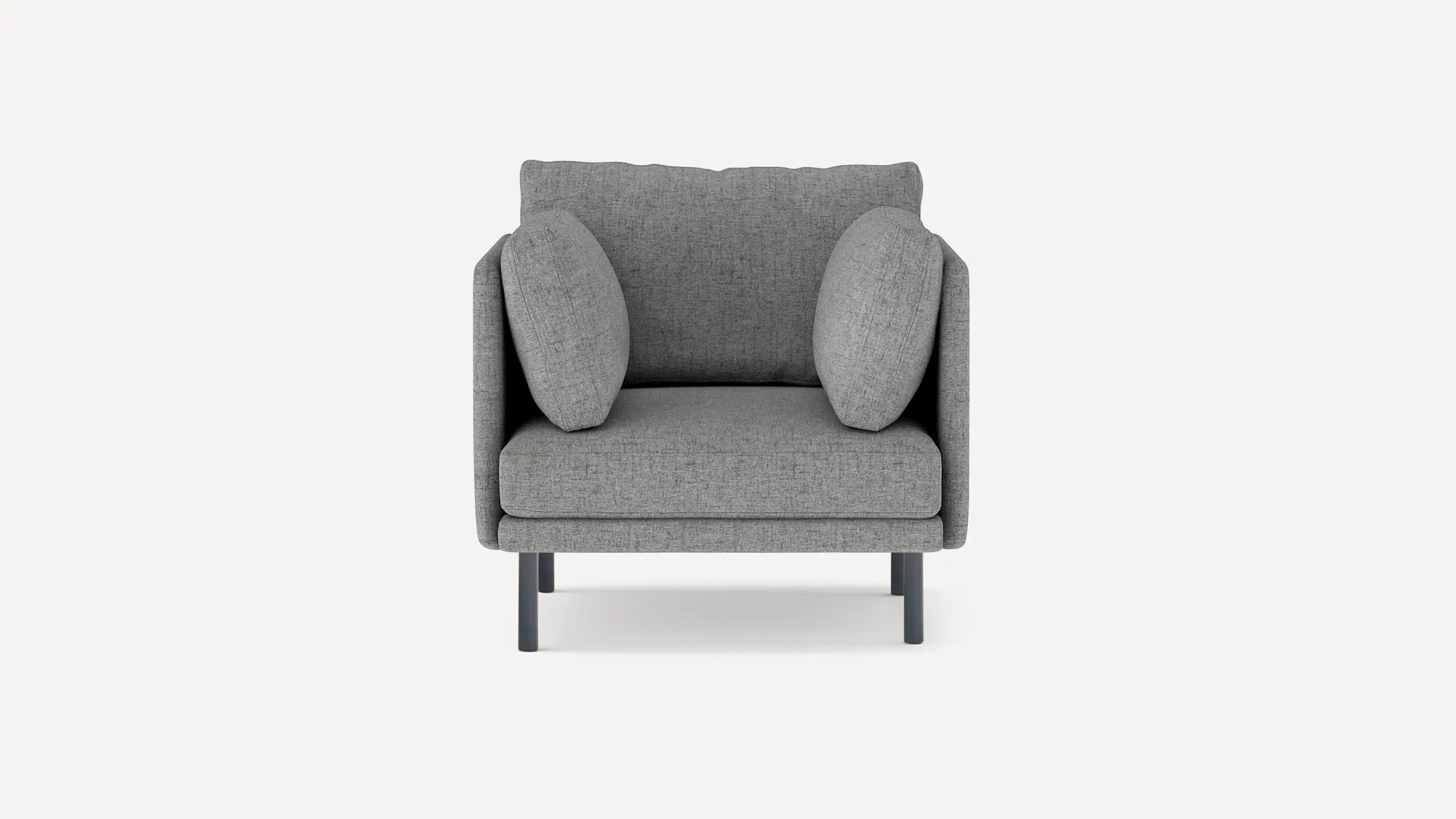 Modern grey fabric armchair with a cushioned back, two round side pillows, and black metal legs on a white background.