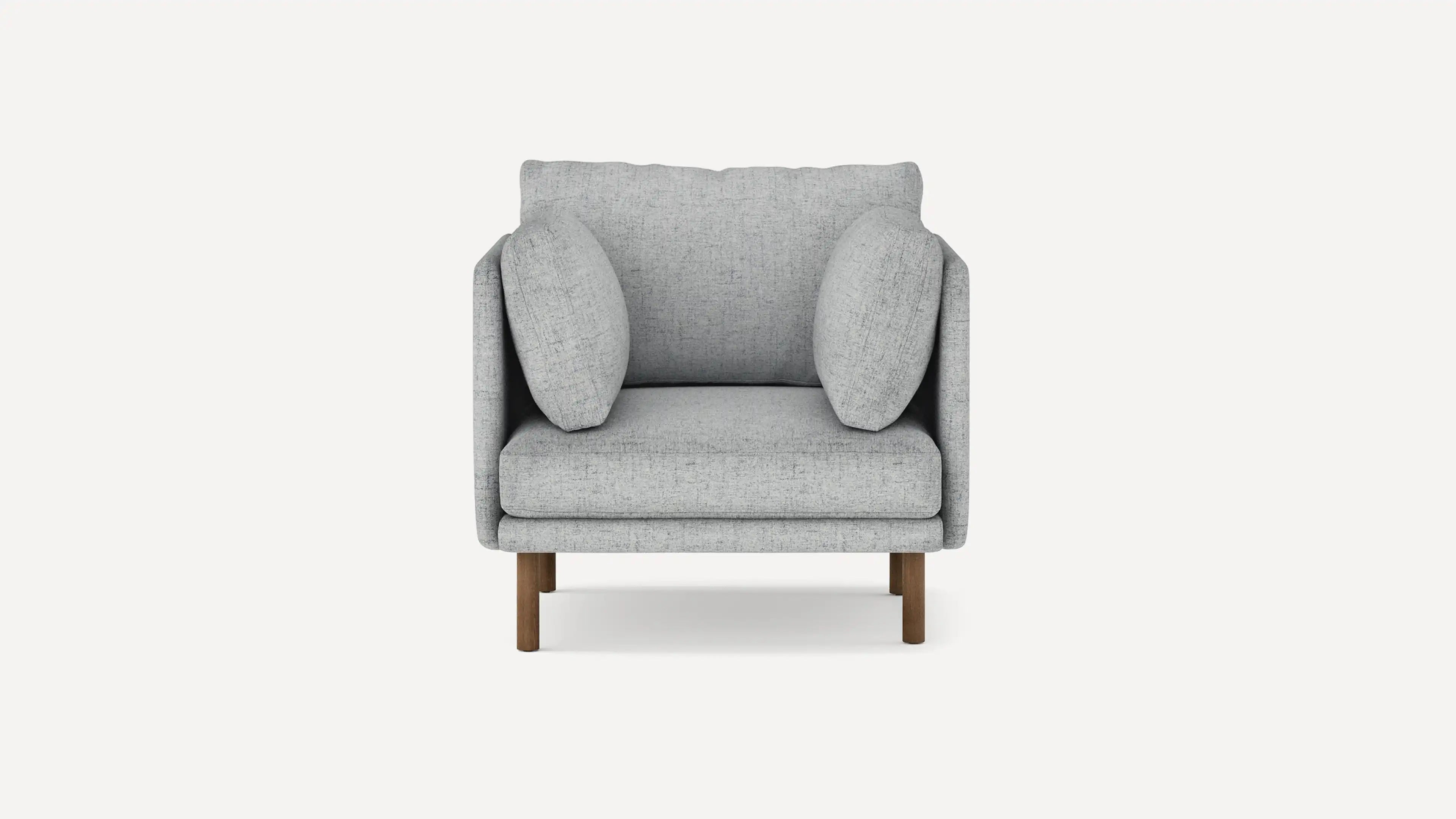 Modern light gray fabric armchair with cushioned seat, backrest, two side pillows, and wooden legs.