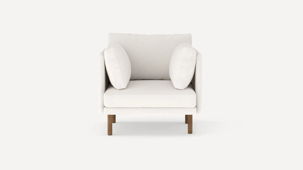 Front view of a modern, plush white armchair with two side cushions and wooden legs on a plain background.