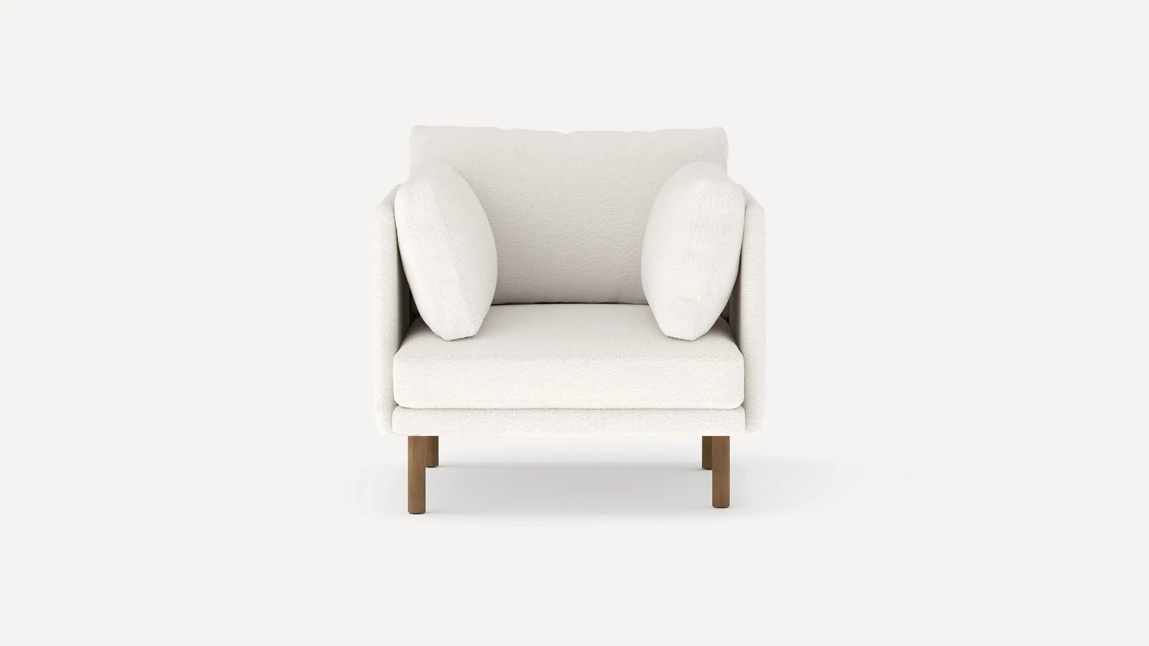 Front view of a modern, plush white armchair with two side cushions and wooden legs on a plain background.