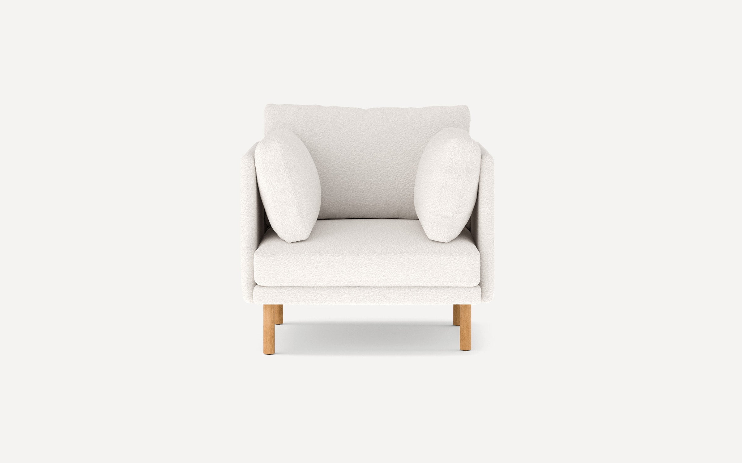 Modern white armchair with plush cushions and wooden legs, designed for comfort and style, shown from the front.
