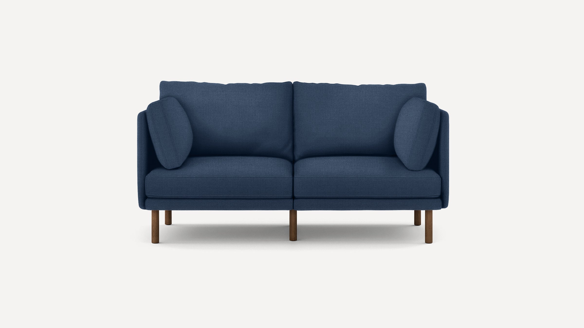 Modern navy blue fabric sofa with two cushions and wooden legs, set against a plain white background.