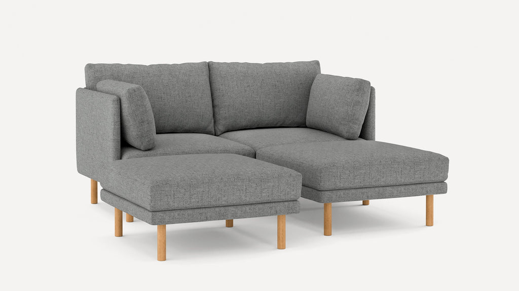 Gray fabric sectional sofa with wooden legs, featuring a chaise lounge and plush back cushions, modern design.