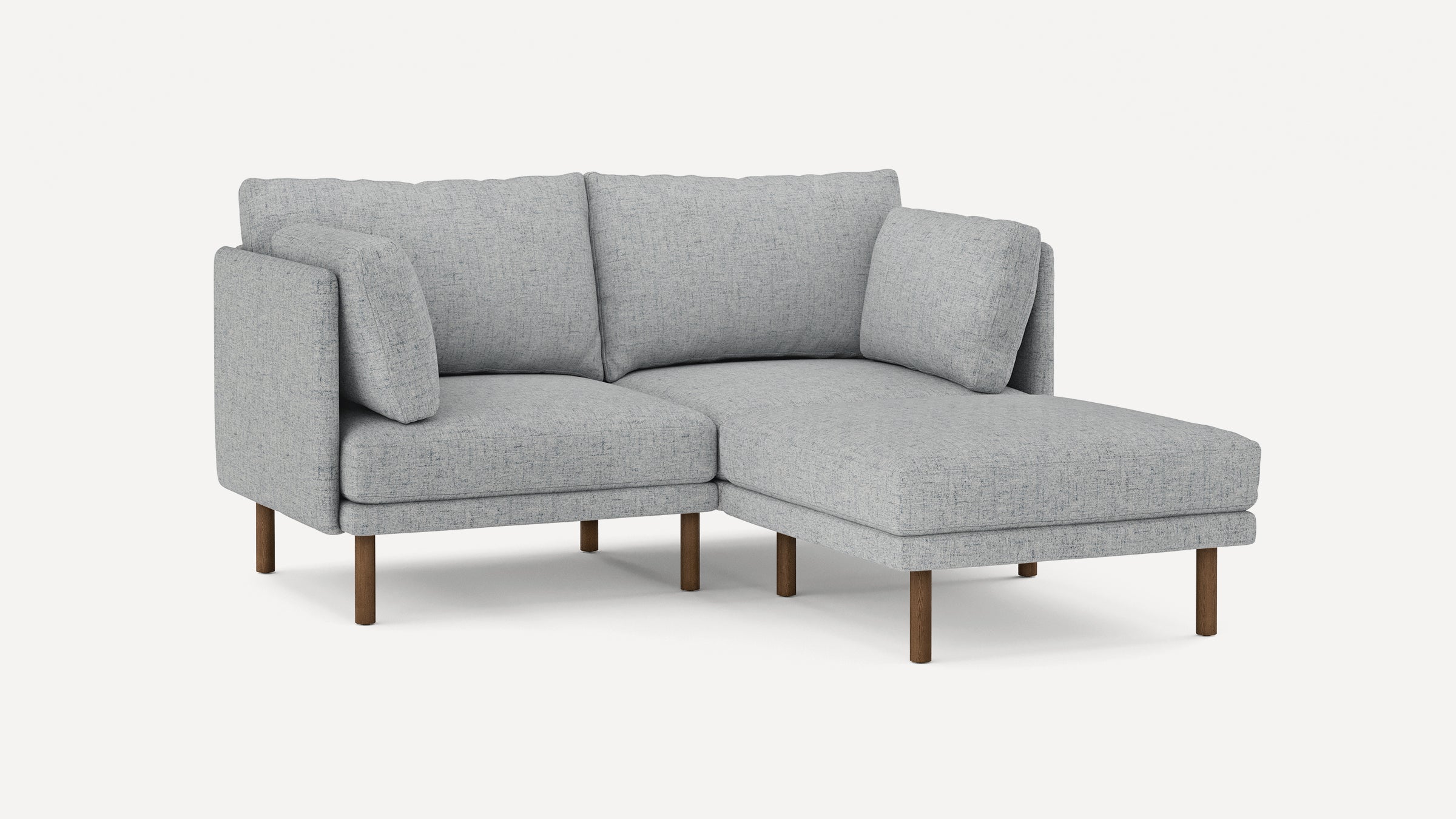 Light gray modern sectional sofa with fabric upholstery, three back cushions, two smaller side cushions, and wooden legs.