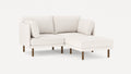 Modern white sectional sofa with textured fabric, wooden legs, and cushioned seats, featuring a chaise lounge on the right side.