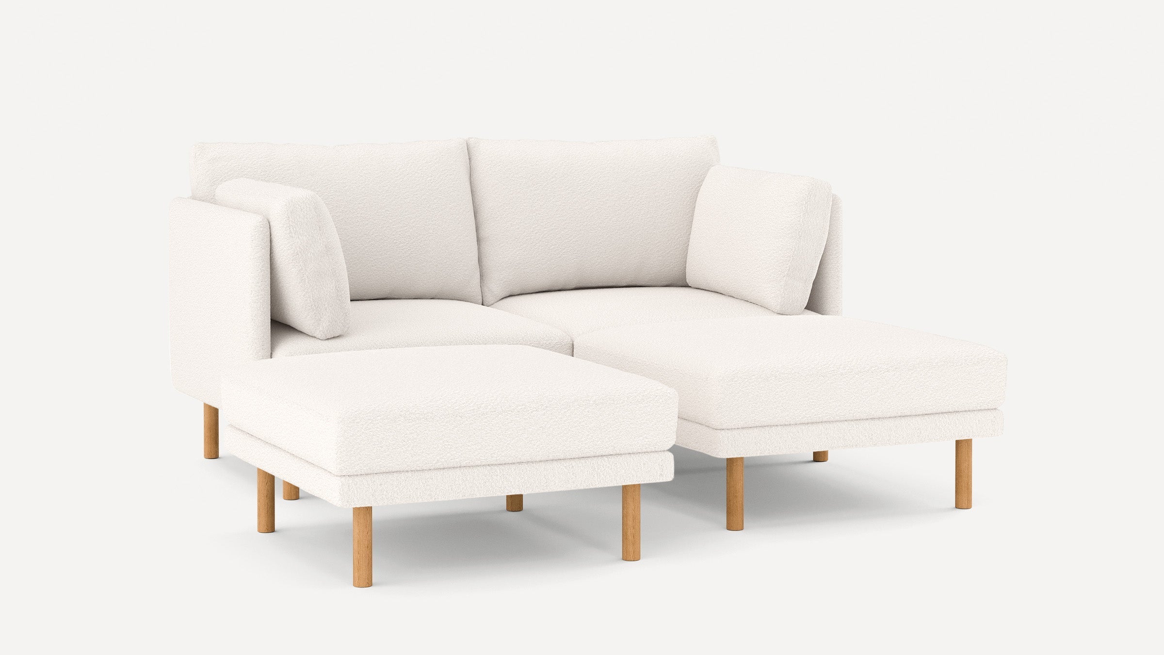 Modern white sectional sofa with wooden legs, plush cushions, and a left-facing chaise lounge, minimalistic design.