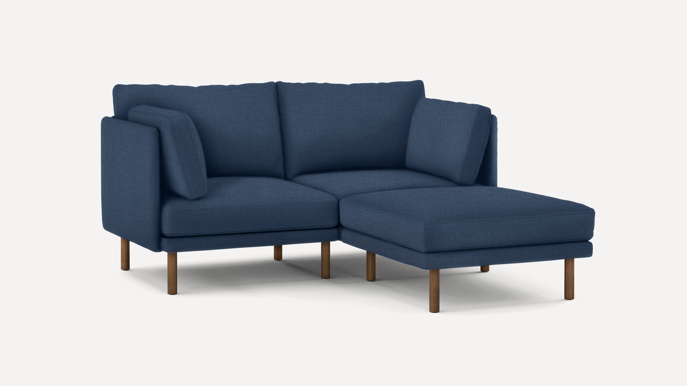 modern navy blue fabric sectional sofa with wooden legs and clean lines on the back, featuring a chaise lounge and matching ottoman