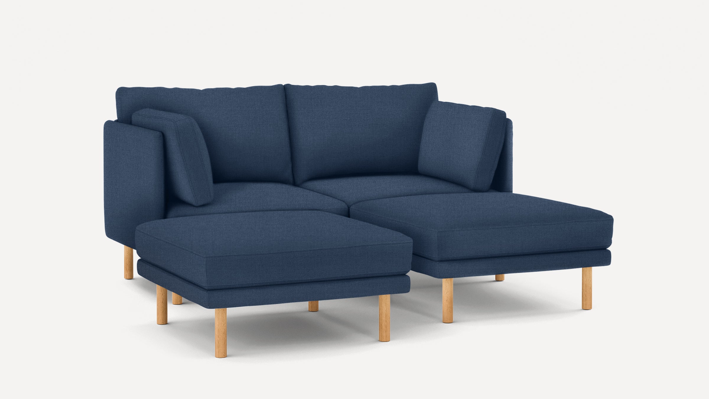 Modern navy blue L-shaped sectional sofa with wooden legs and two matching cushions on a white background.