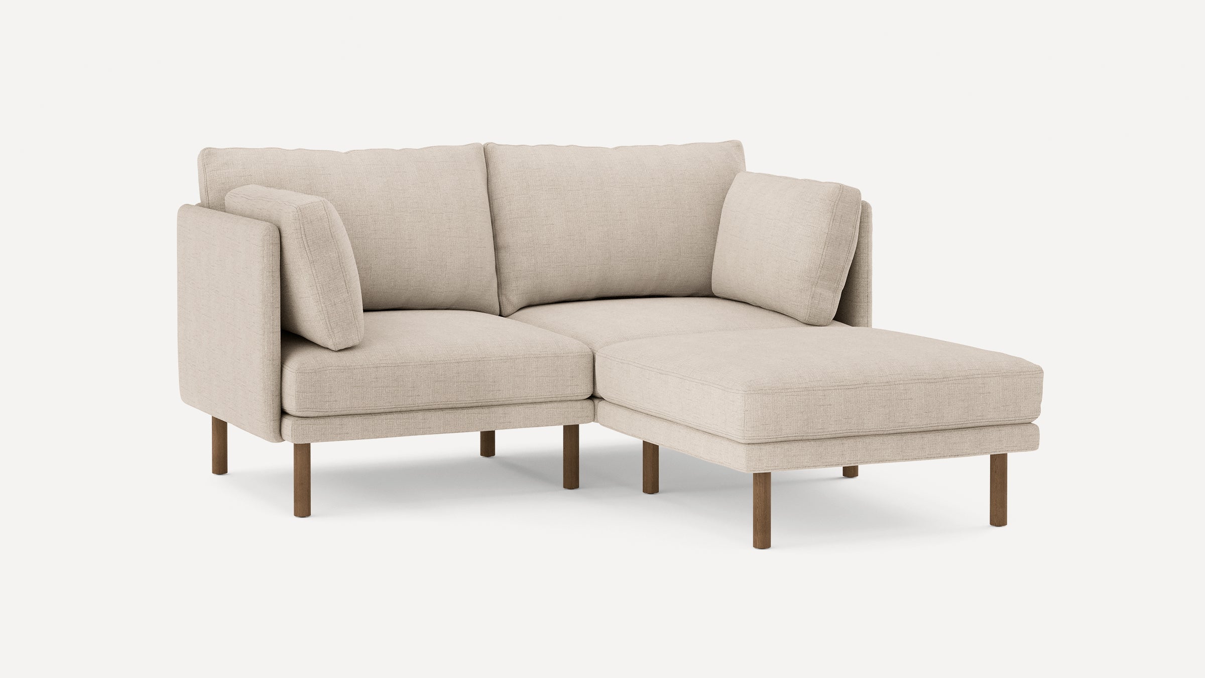 modern beige fabric sectional sofa with wooden legs and clean lines on the back, featuring a chaise lounge and matching ottoman