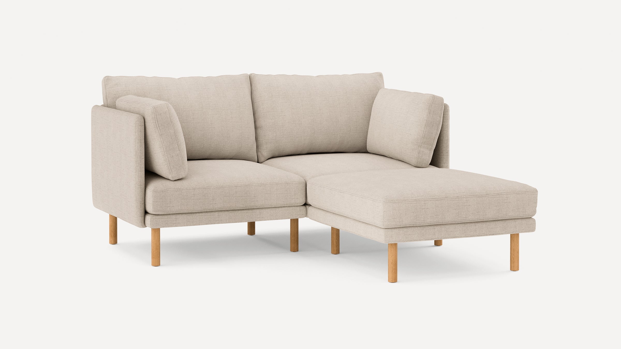 beige fabric sectional sofa with wooden legs and clean lines on the back, featuring a chaise lounge and matching cushions