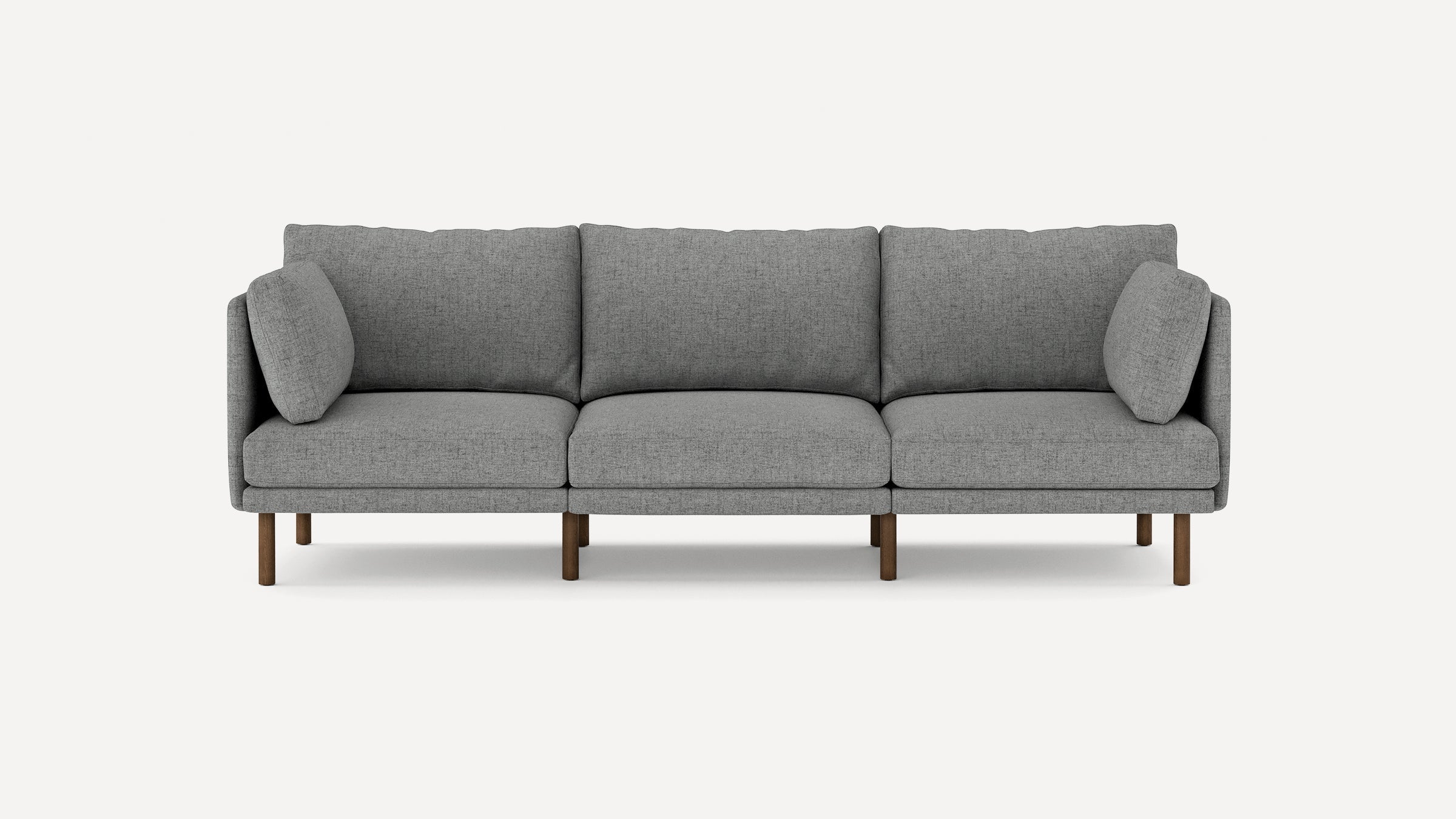 Modern three-seater grey fabric sofa with clean lines, plush cushions, and wooden legs against a white background.