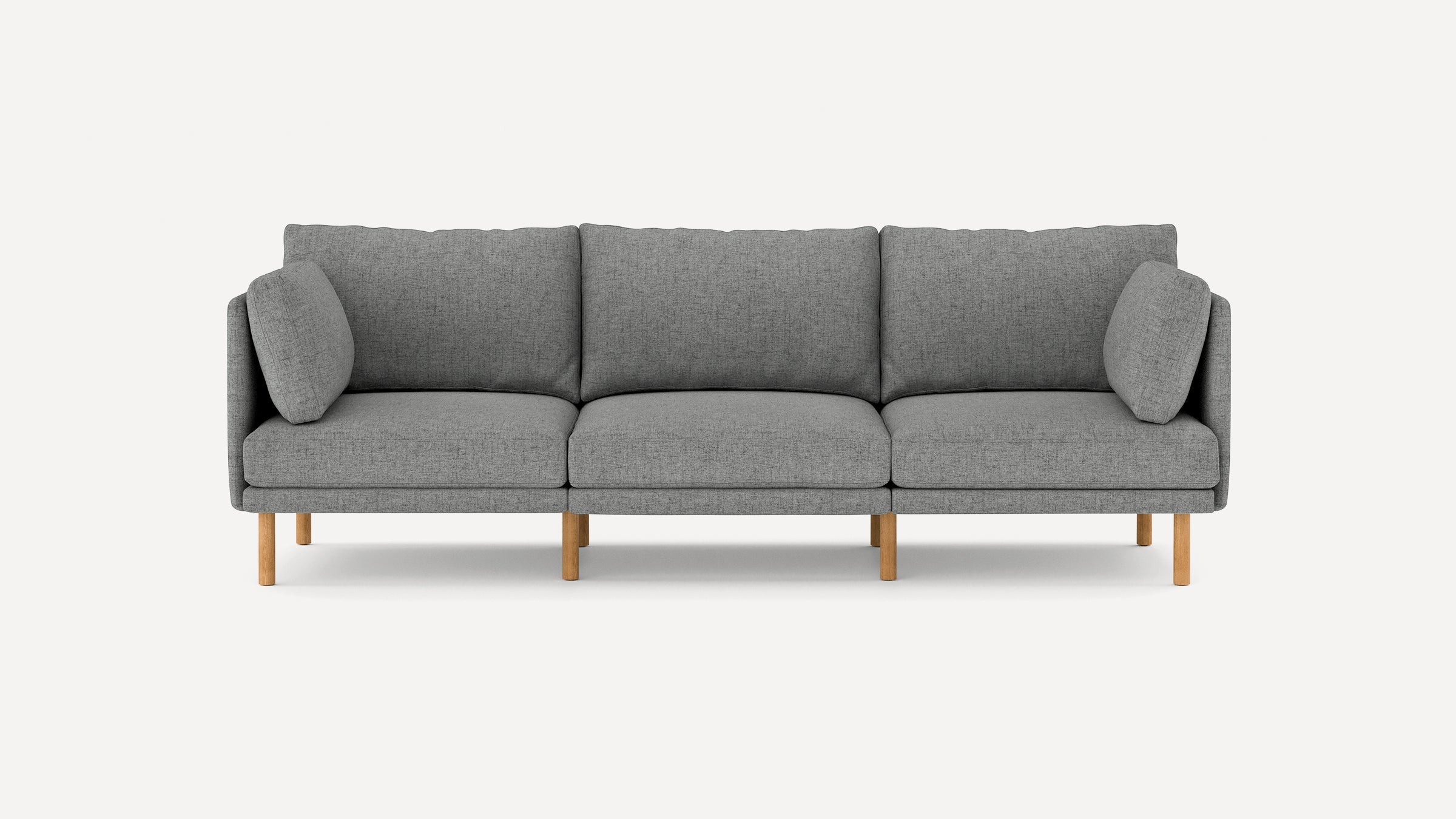Modern three-seater gray fabric sofa with wooden legs and two side cushions, set against a plain white background.