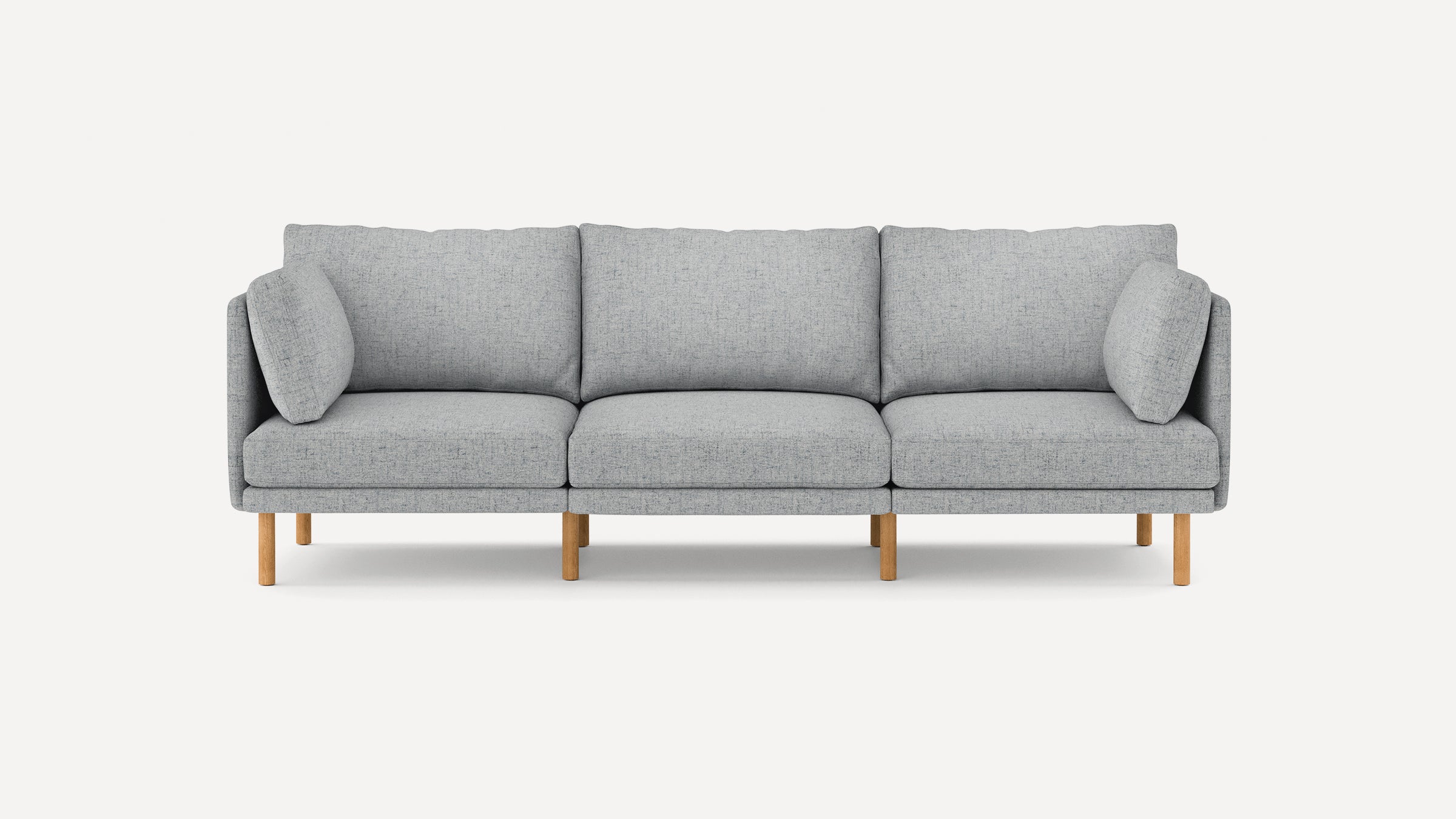 Modern light gray three-seater sofa with wooden legs, featuring clean lines and plush cushions for comfortable seating.