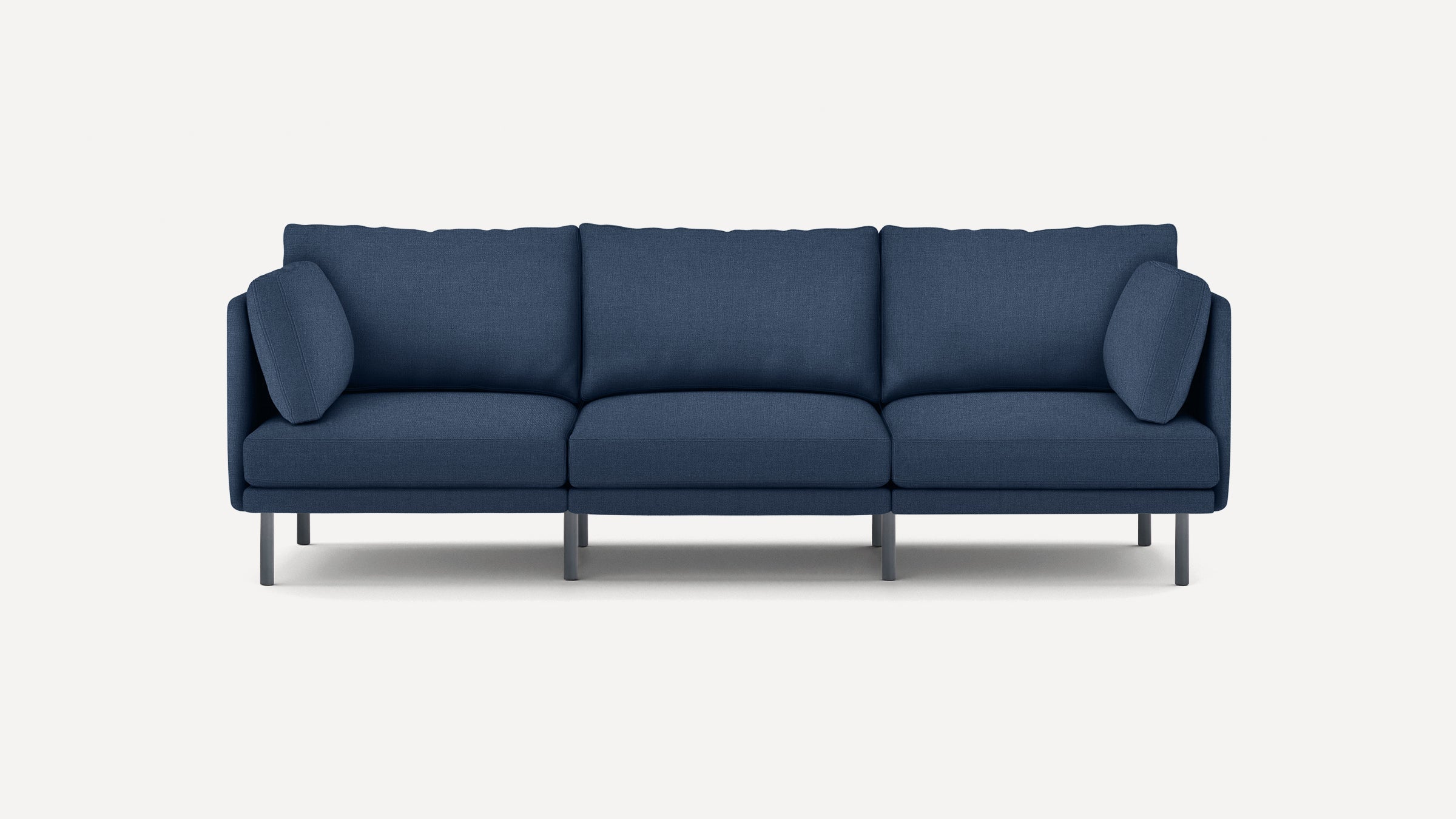 Modern three-seater sofa in deep blue fabric with clean lines, thin metal legs, and matching side cushions.