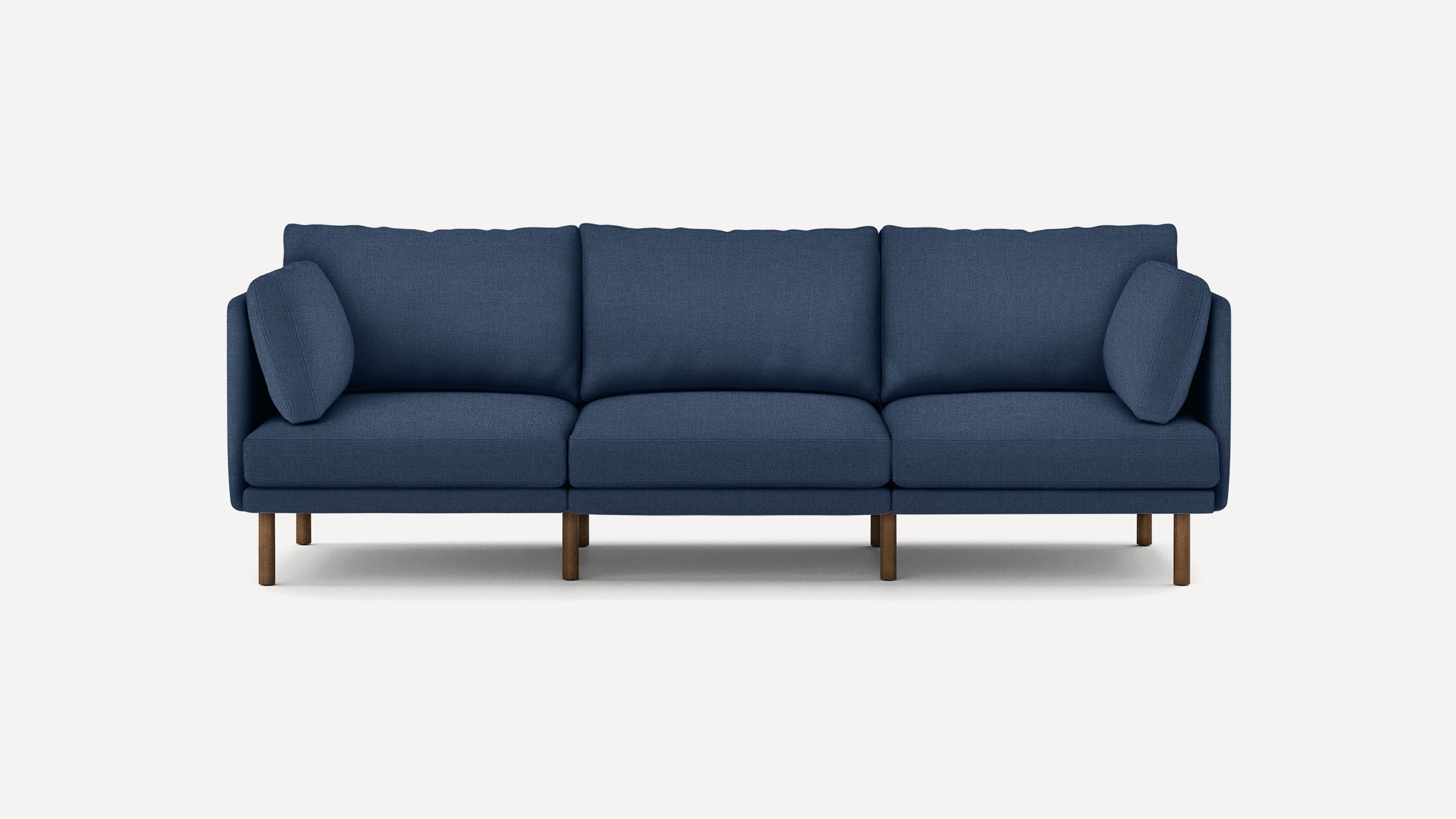 Modern navy blue three-seater sofa with plush cushions and wooden legs, set against a plain white background.
