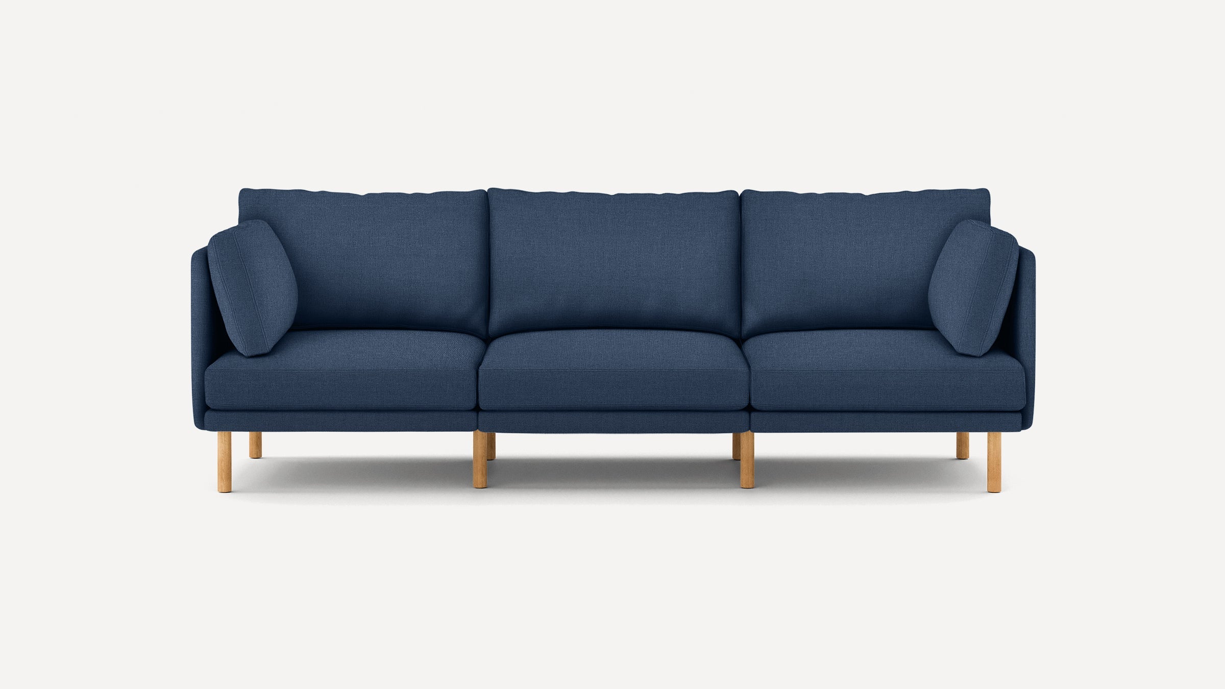 Modern navy blue three-seater sofa with wooden legs and two matching rectangular side cushions, set against a plain white background.