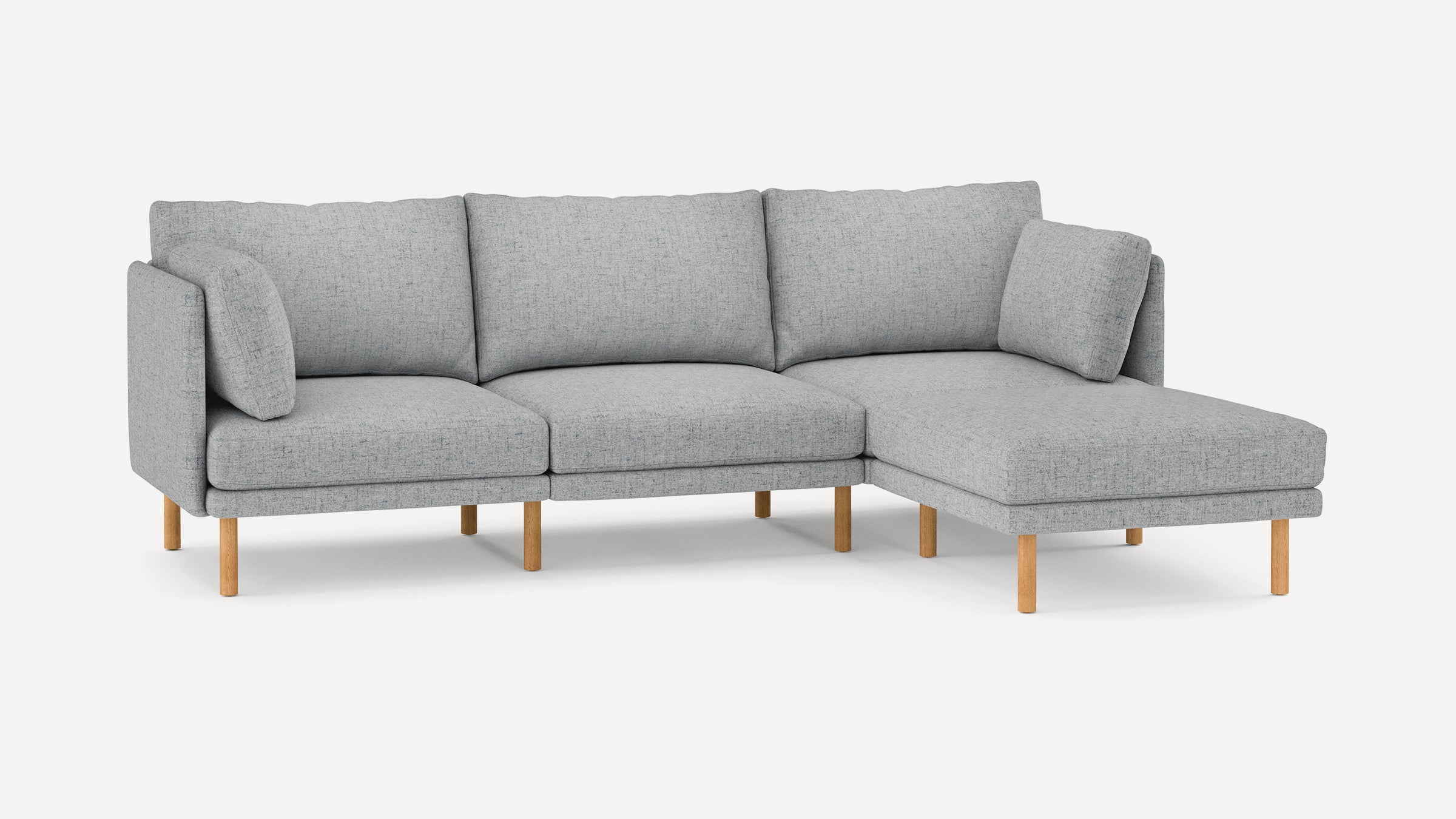 Modern light gray L-shaped sectional sofa with wooden legs and plush back and side cushions.