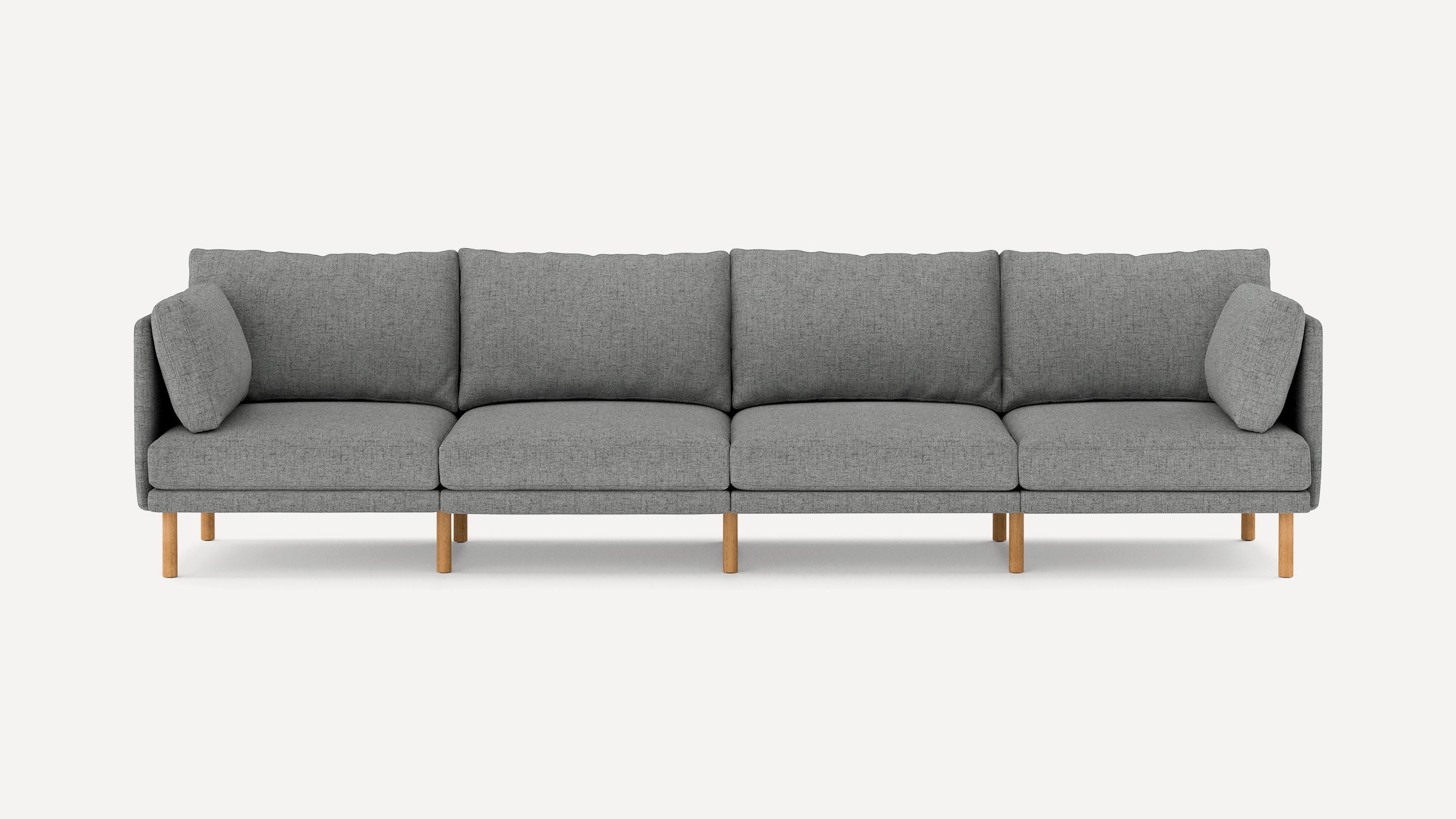Modern long grey fabric sofa with wooden legs, clean lines, and matching cushions on both ends.